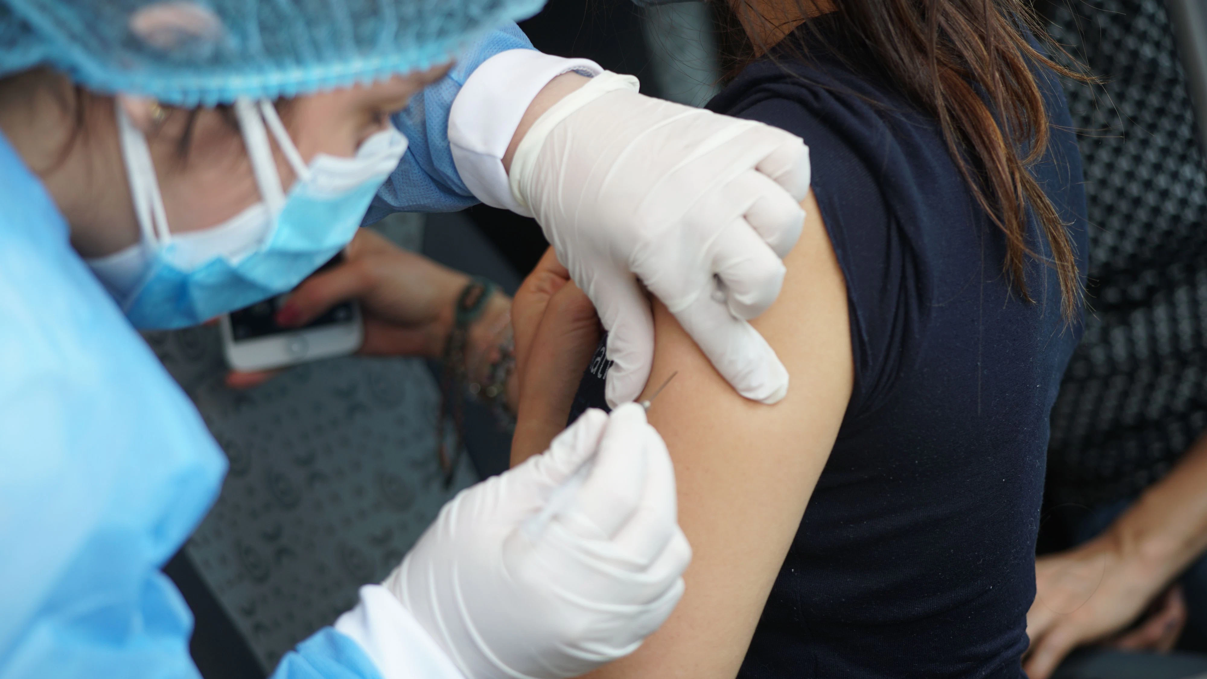 Download von www.picturedesk.com am 22.12.2021 (10:50).  Editorial use only .Person being injected with the Pfizer-BioNTech BNT162b2 Covid-19 vaccine. The vaccine consists of strands of mRNA (messenger ribonucleic acid) encased in lipid nanoparticles. The mRNA codes for a mutated version of the viral spike protein found on the surface of the SARS-CoV-2 coronavirus that causes Covid-19. When injected into the body the mRNA is taken up by the body's cells, which manufacture copies of the protein. The proteins stimulate an immune response, causing the body to produce antibodies against the spike protein. This means that the body is primed to attack the virus should it be encountered after vaccination, preventing disease. Photographed in Bogota, Colombia. - 20211222_PD0022 - Rechteinfo: Rights Managed (RM) Nur für redaktionelle Nutzung!