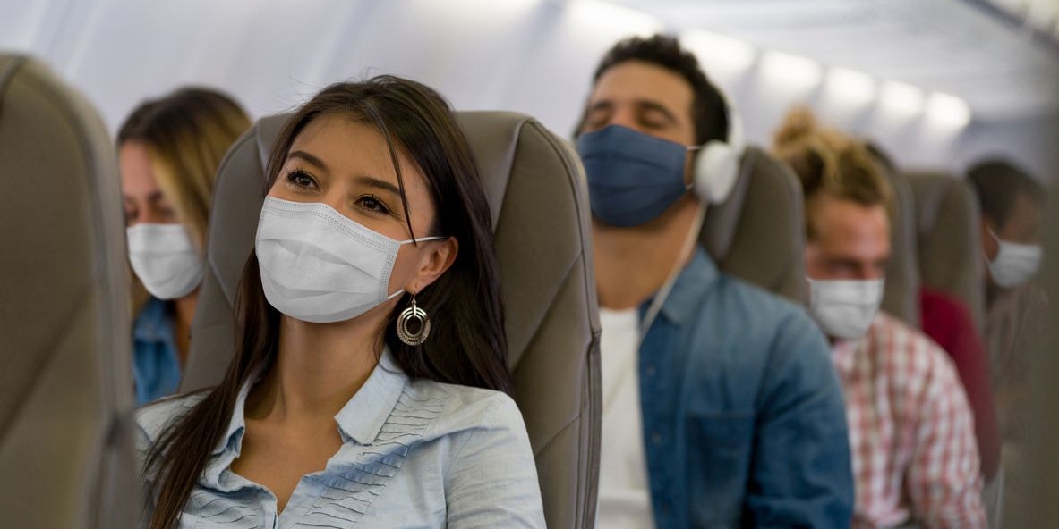 Portrait of a Latin American Woman traveling by plane wearing a facemask during the COVID-19 pandemic