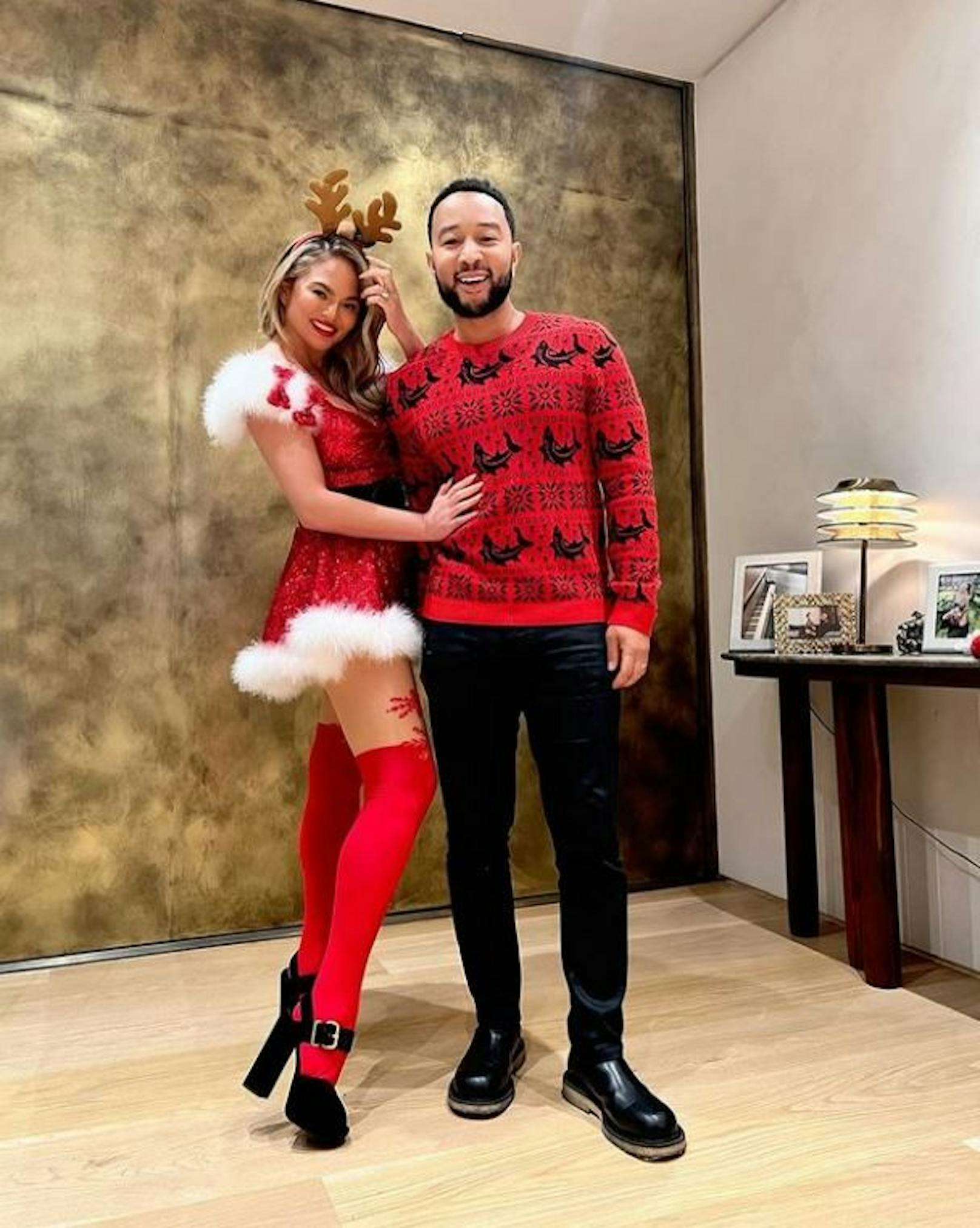 Chrissy Teigen und ihr Ehemann John Legend in ihren Weihnachtsoutfits.