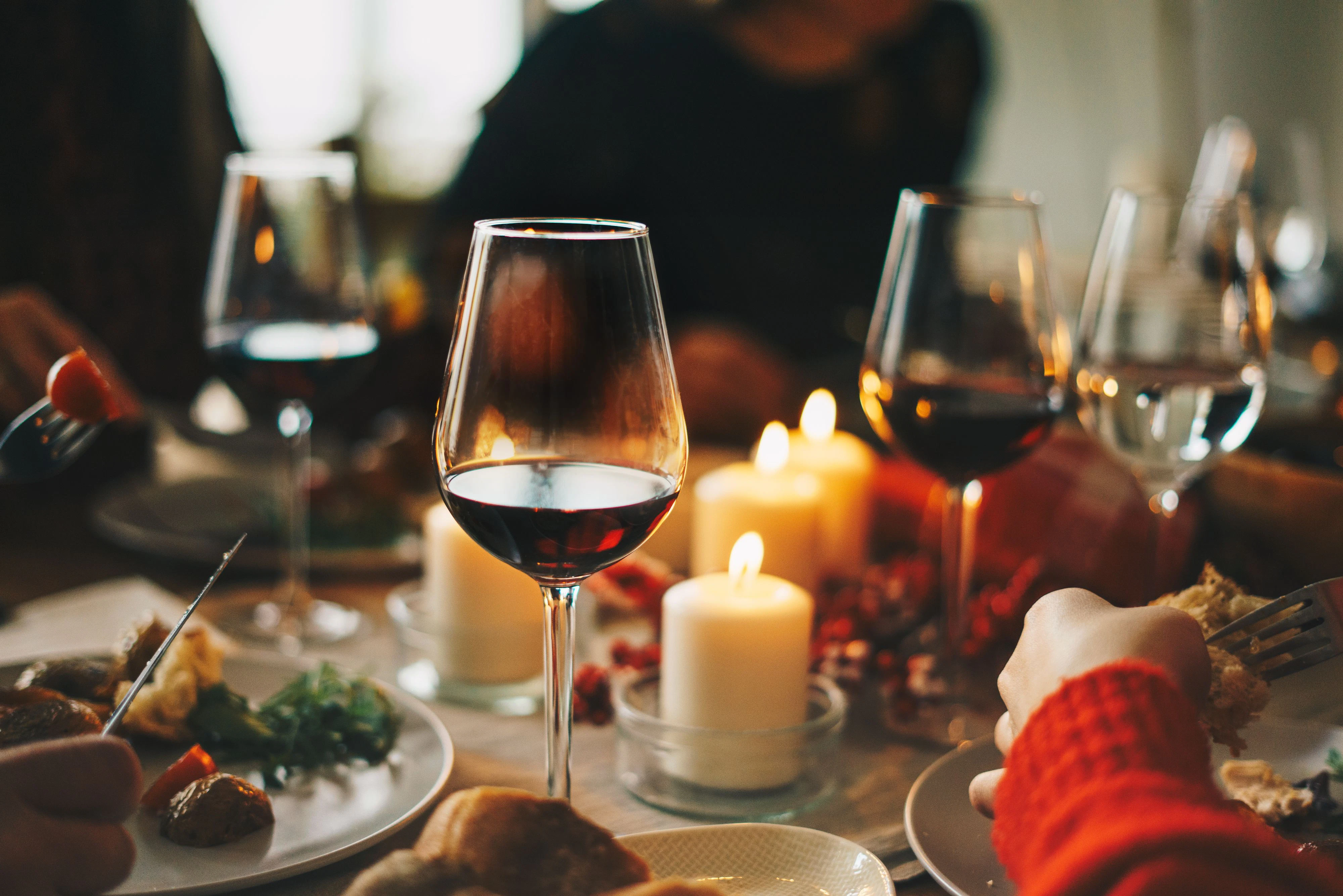 Red wine glasses at the decorated dinner table