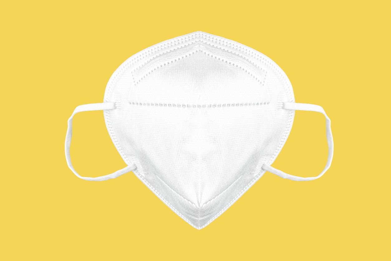 front view of FFP2 face mask, respirator isolated on yellow background, protective face mask to lower risk of covid-19 coronavirus transmission