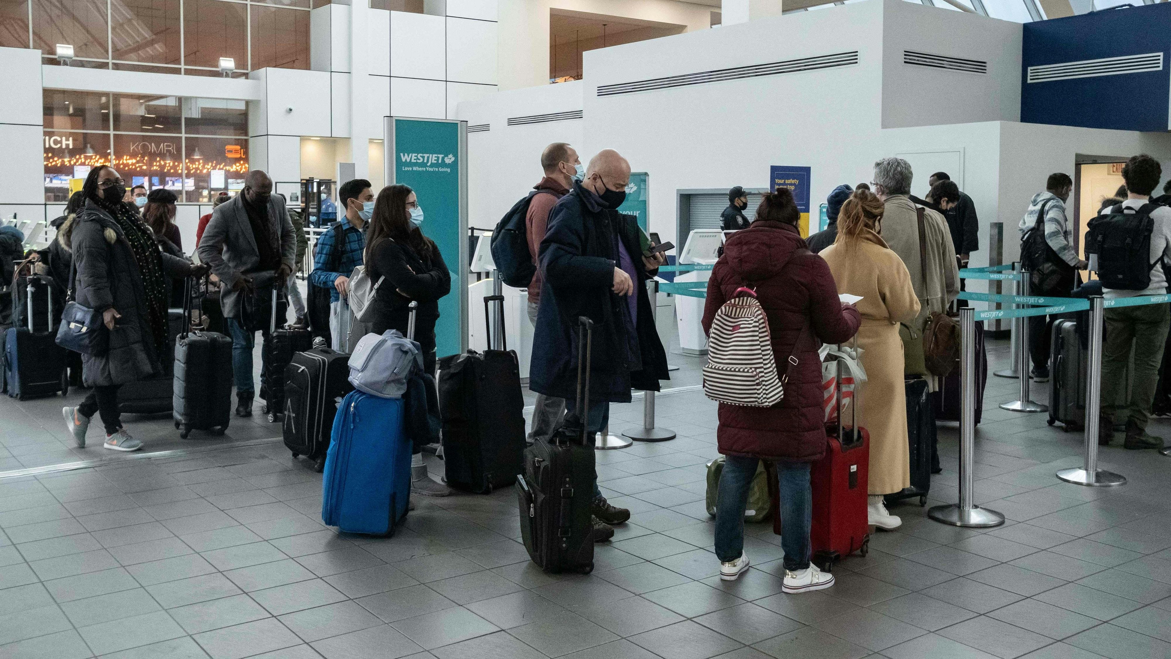 Download von www.picturedesk.com am 25.12.2021 (06:56).  Travelers wait in line to check-in at LaGuardia Airport in New York, on December 24, 2021. - On Christmas Eve, airlines, struggling with the Omicron variant of Covis-19, have canceled over 2,000 flights globally, 454 of which are domestic, into or out of the US (Photo by Yuki IWAMURA / AFP) - 20211224_PD2236 - Rechteinfo: Rights Managed (RM) Nur für redaktionelle Nutzung! Werbliche Nutzung erfordert Freigabe: bitte schicken Sie uns eine Anfrage.