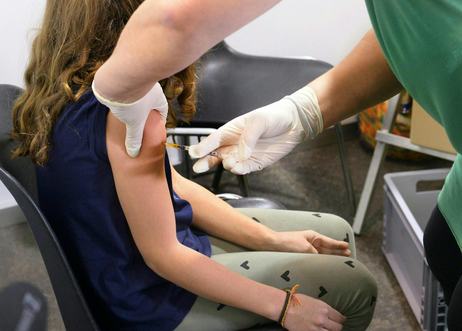 Ein Kind bekommt die Corona-Schutzimpfung im Rahmen der "Kinder-Impflinie" in Tulln. Ein Volksbegehren will die Impfpflicht kippen.