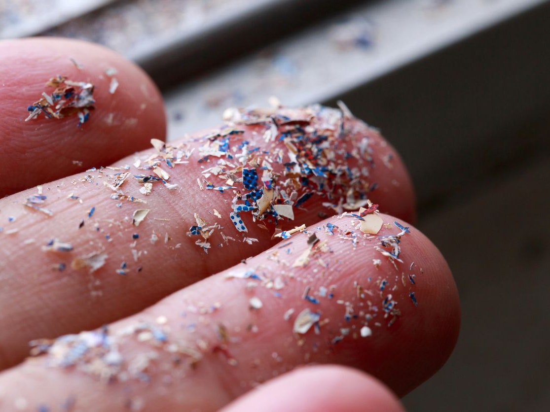 Close up side shot of microplastics lay on people hand.Concept of water pollution and global warming. Climate change idea.