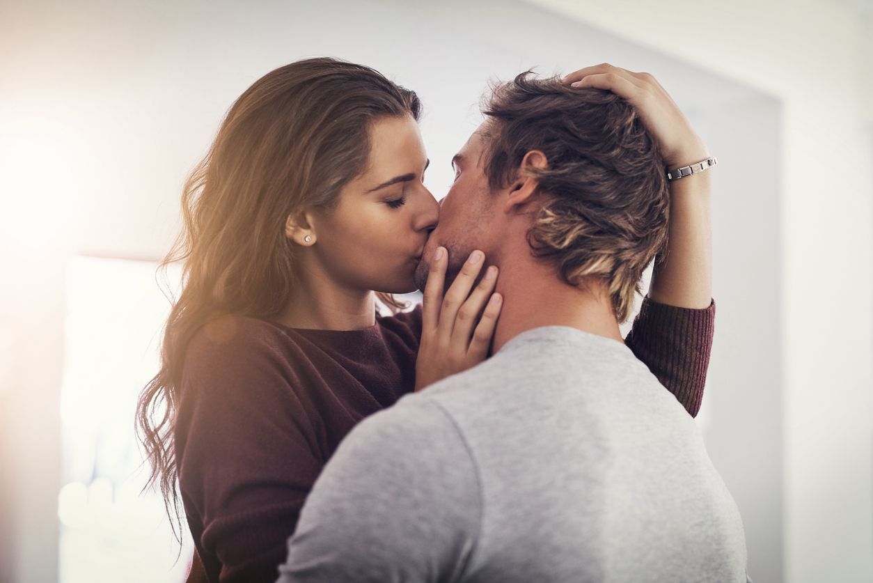 Shot of a young couple making out in the kitchen