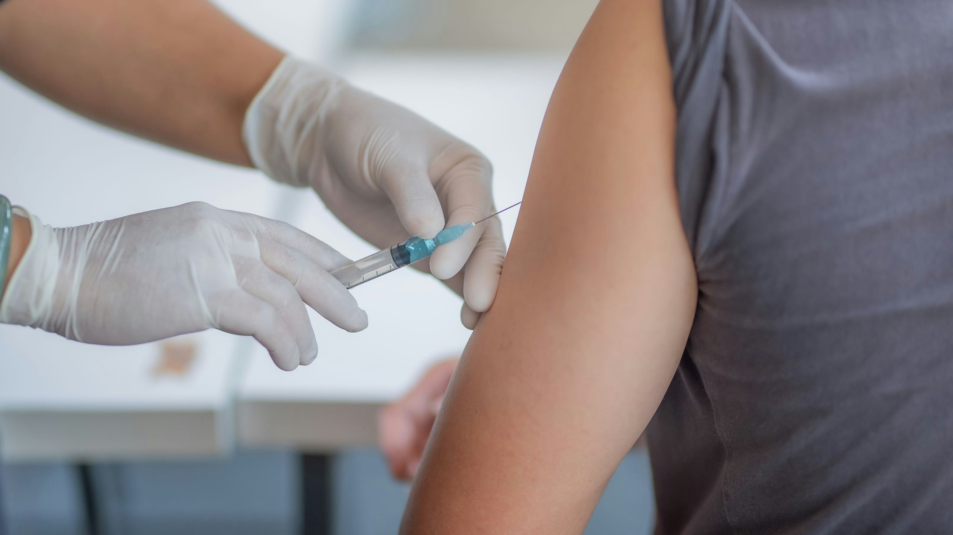The doctor is injecting male patients.In the medical's hand have syringes.