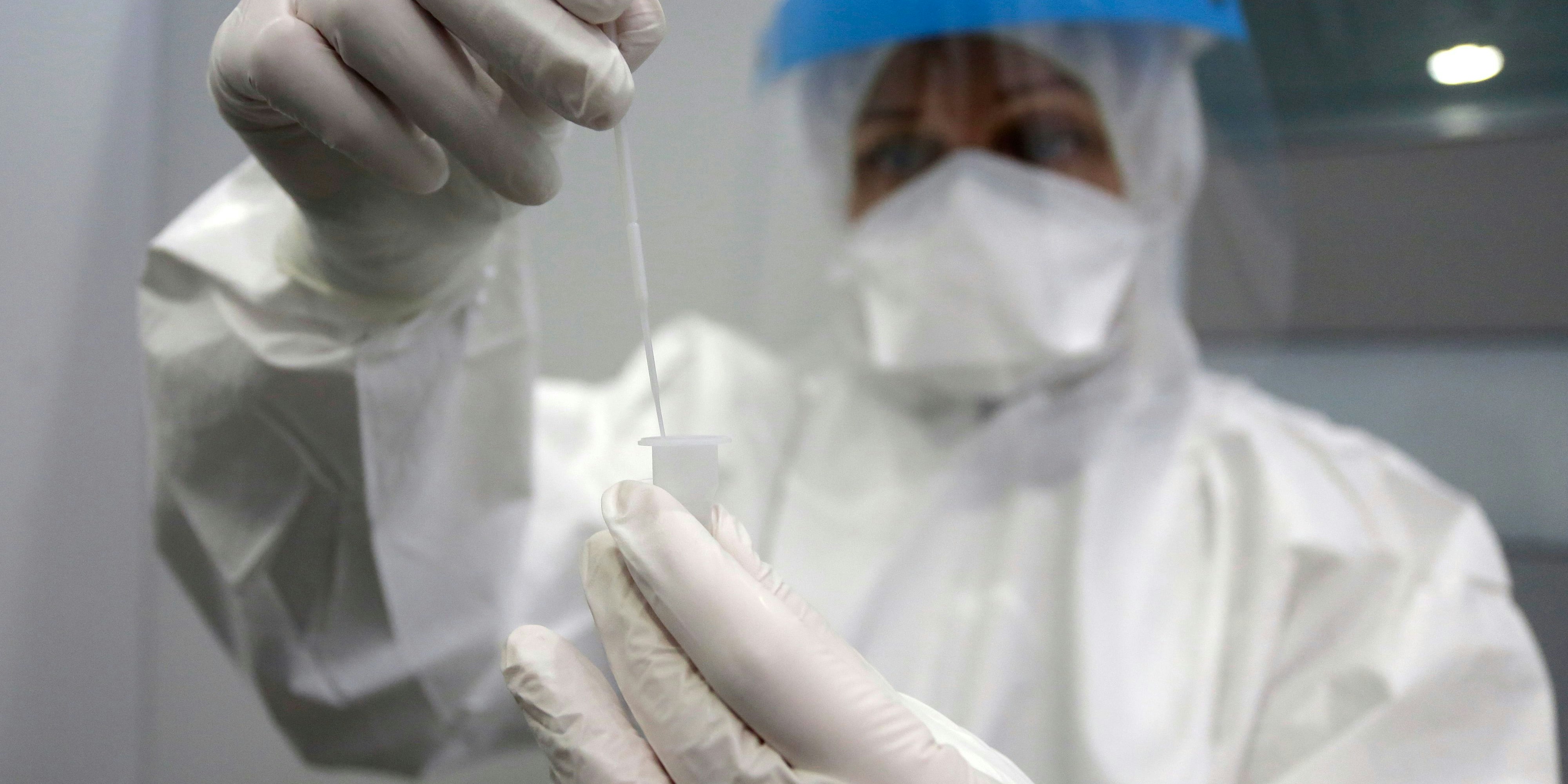 Pflicht-Coronatests am Münchner Flughafen: Eine Mitarbeiterin nimmt einen Abstrich beim Test to Fly Center in Terminal 2. - 20201119_PD9585 - Rechteinfo: Rights Managed (RM)