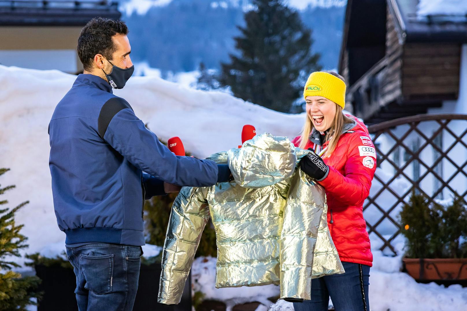 Martin Fourcade schenkt Katharina Liensberger eine goldene Jacke. 