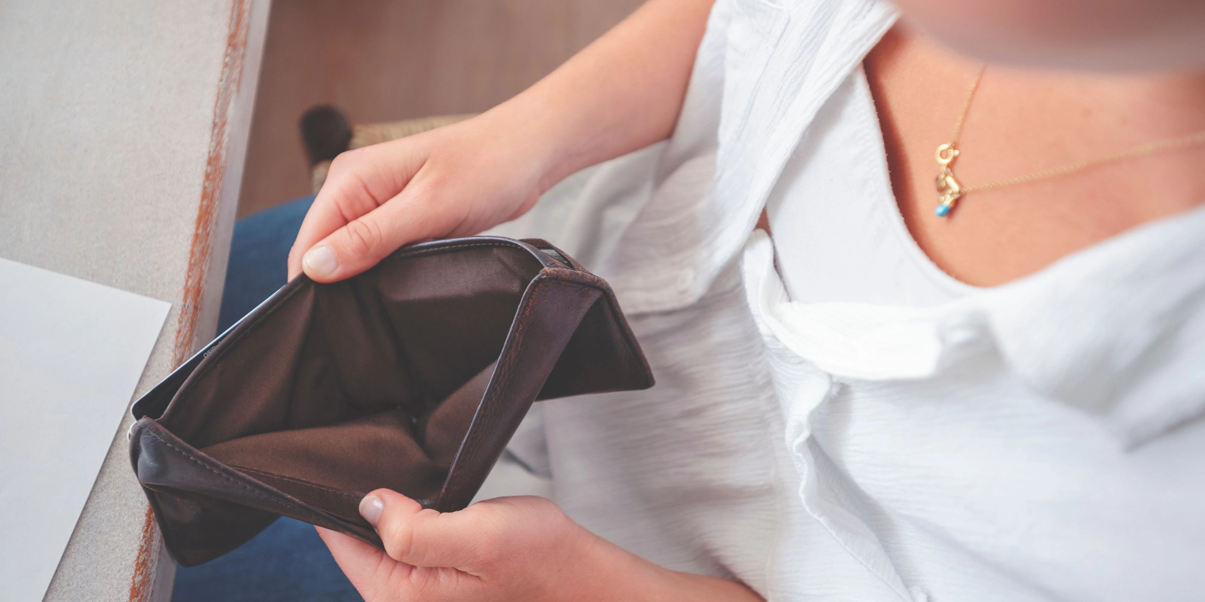 Woman opening an empty wallet. Poverty, budget and overspending concept.