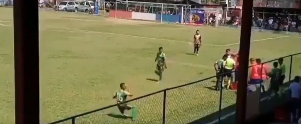 Ein Fußballer wirft sich selbst einen Gegenstand an den Kopf. 