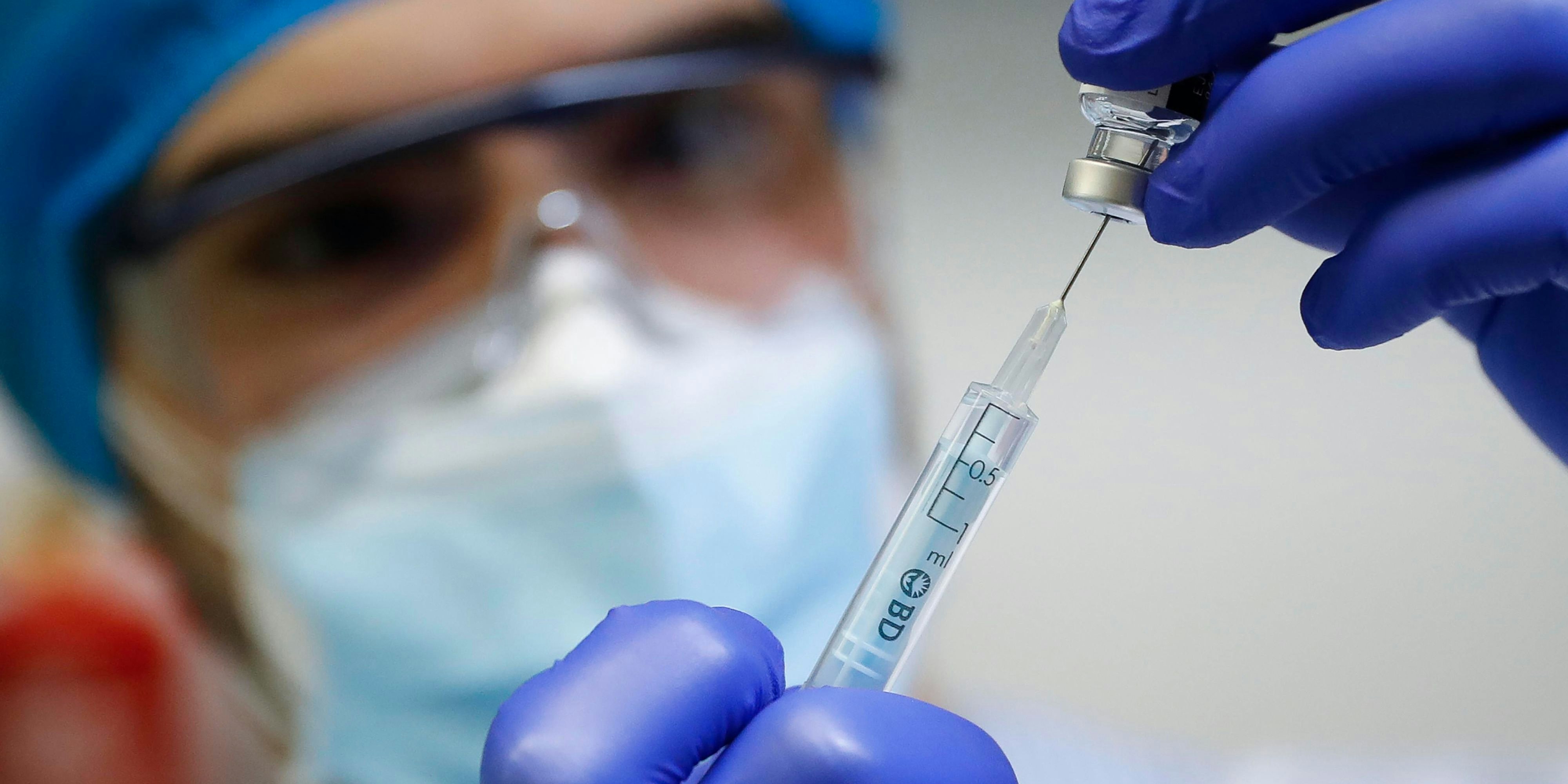 Eine Krankenpflegerin entnimmt eine Dose des Pfizer/Biontech-Vakzins. Symbolfoto