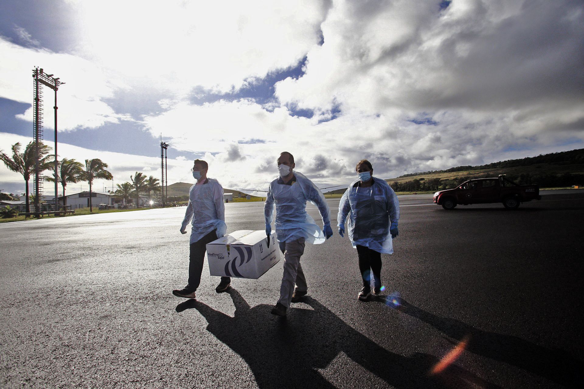 Helfer transportieren Kisten mit Impfdosen am Flughafen von Mataveri auf der chilenischen Osterinsel.