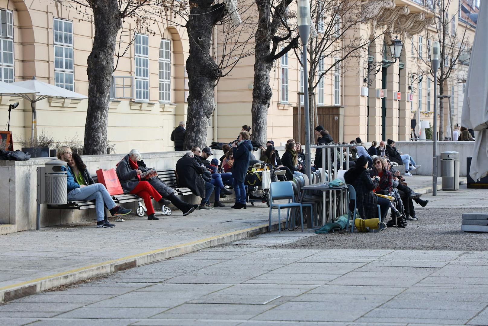 Menschen genießen das schöne Wetter in Wien beim Museumsquartier.
