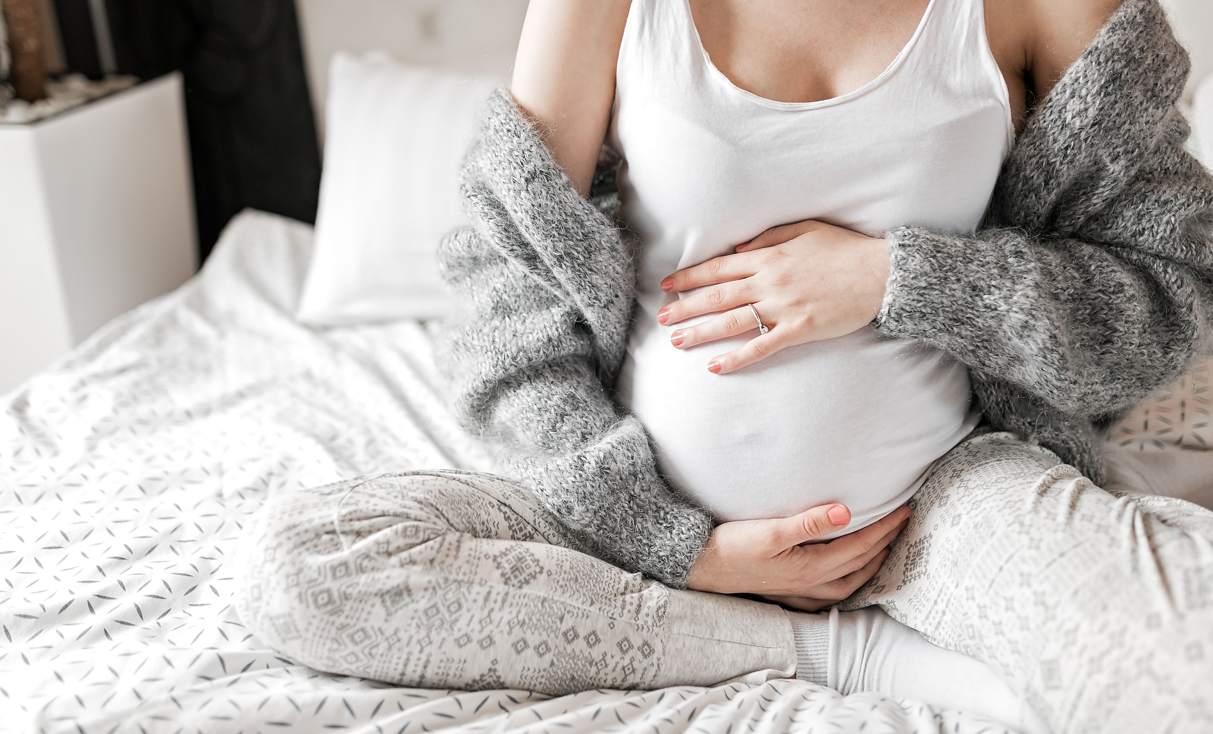 Beautiful young pregnant woman sitting in bedroom