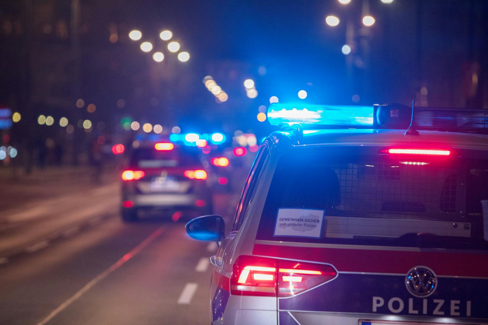Polizeifahrzeuge mit Blaulicht bei einem nächtlichen Einsatz in Wien. Symbolbild