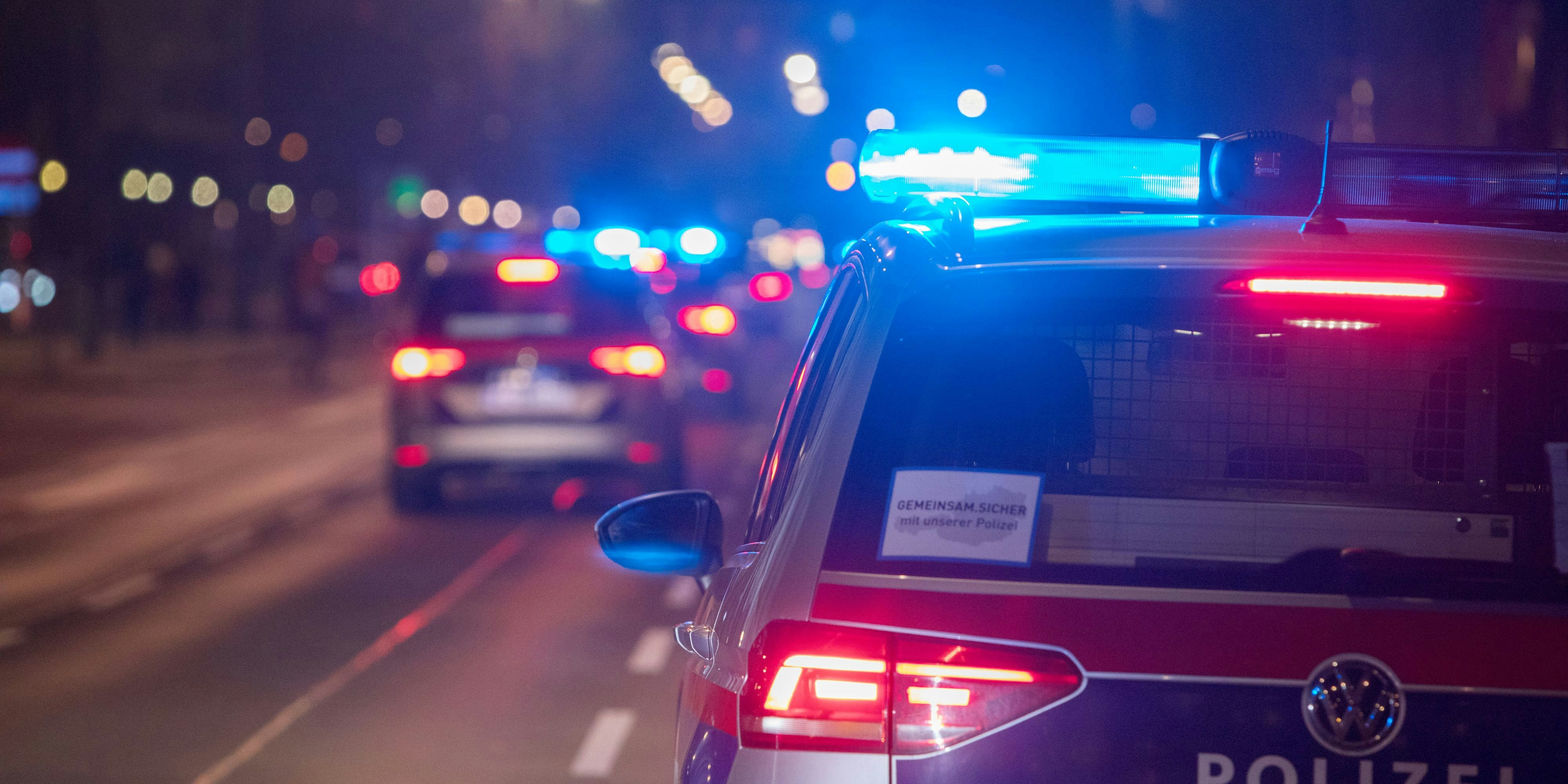 Polizeifahrzeuge mit Blaulicht bei einem nächtlichen Einsatz in Wien. Symbolbild