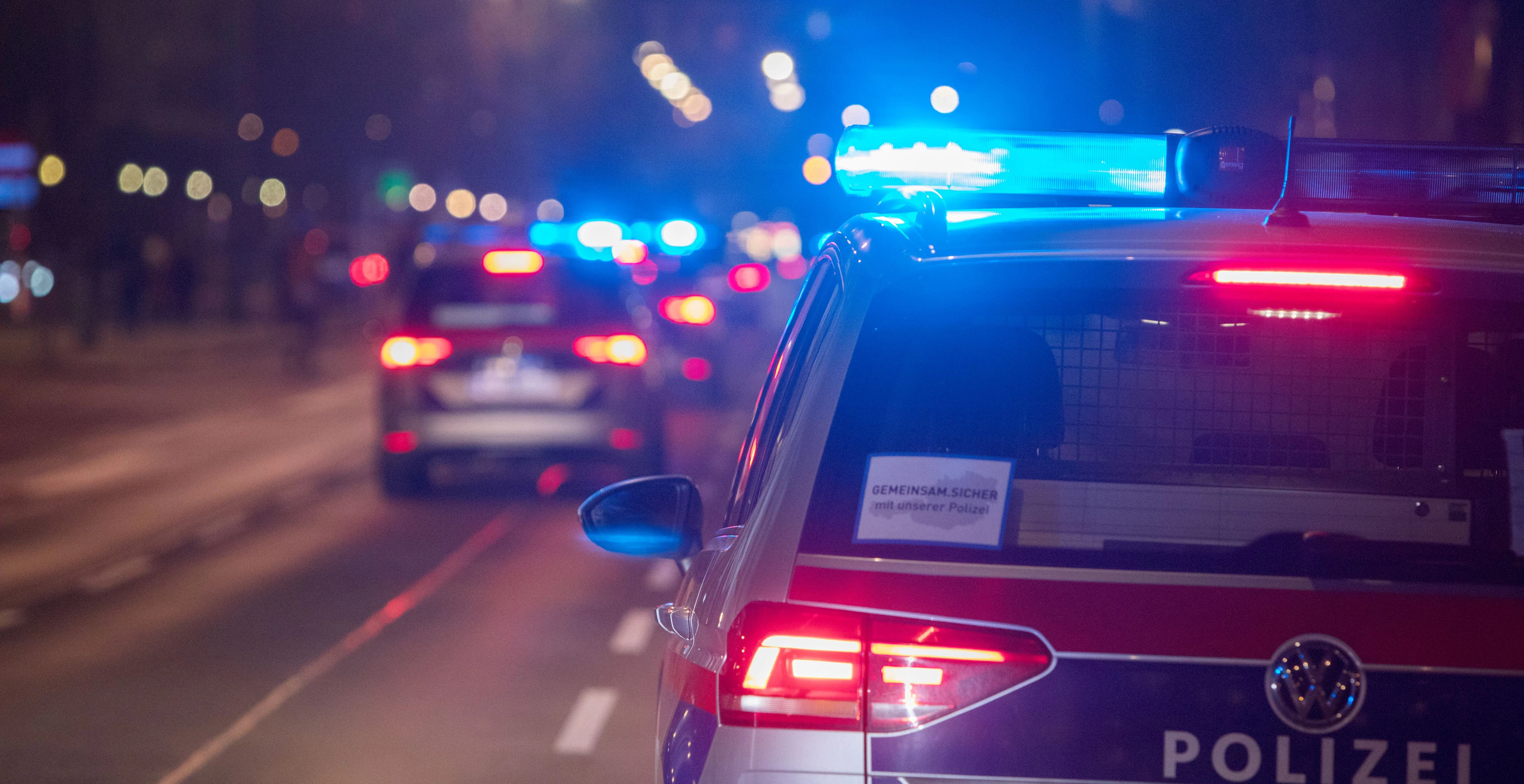 Polizeifahrzeuge mit Blaulicht bei einem nächtlichen Einsatz in Wien. Symbolbild
