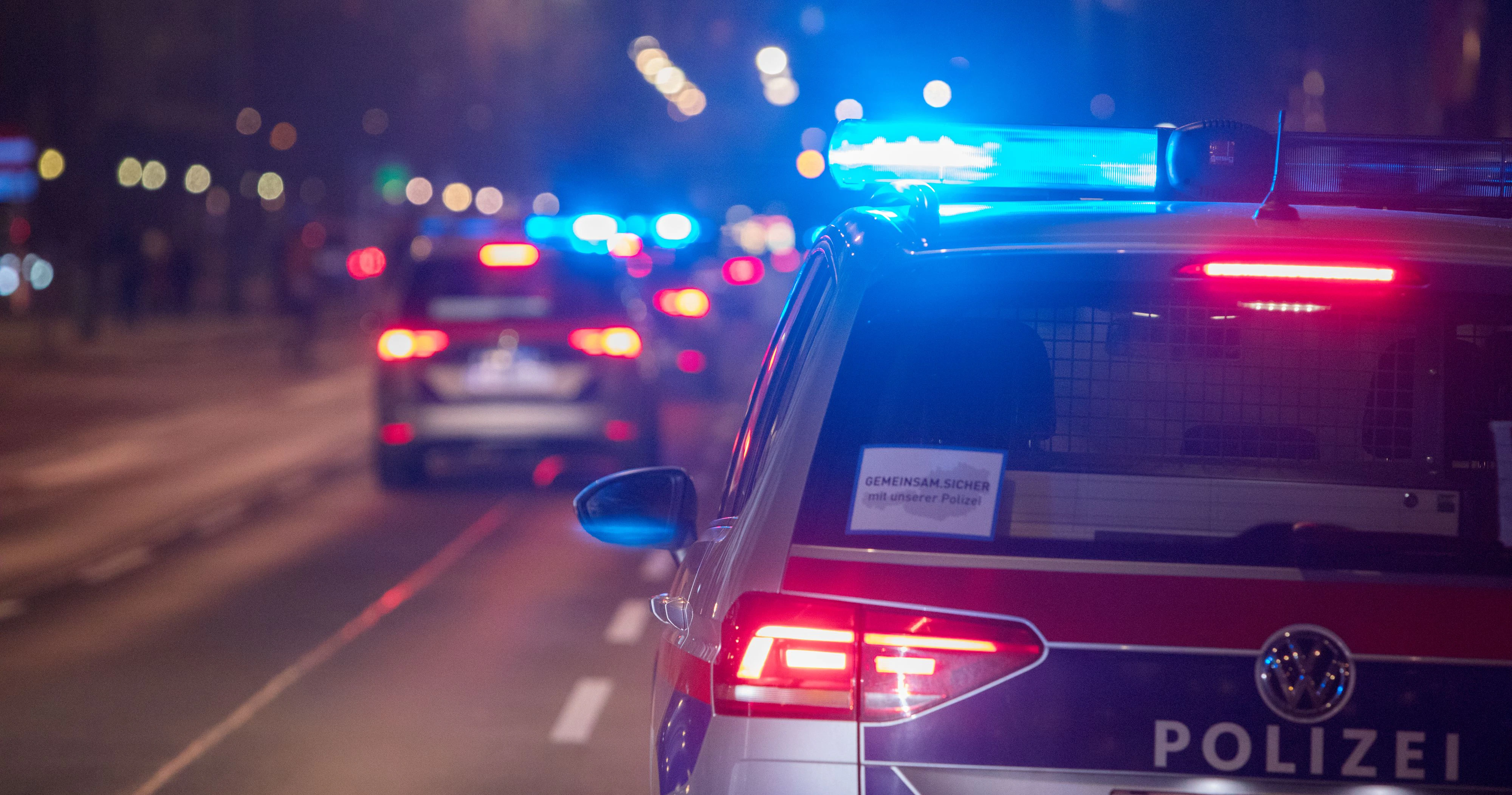 Polizeifahrzeuge mit Blaulicht bei einem nächtlichen Einsatz in Wien. Symbolbild