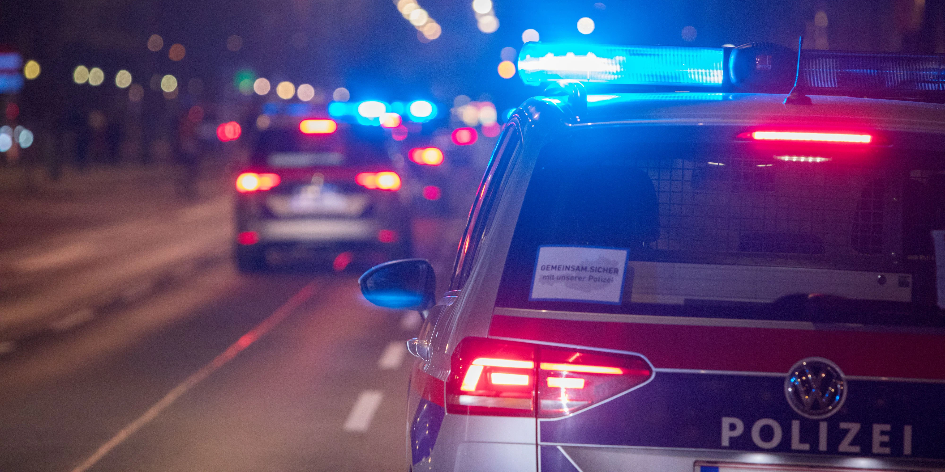 Polizeifahrzeuge mit Blaulicht bei einem nächtlichen Einsatz in Wien. Symbolbild