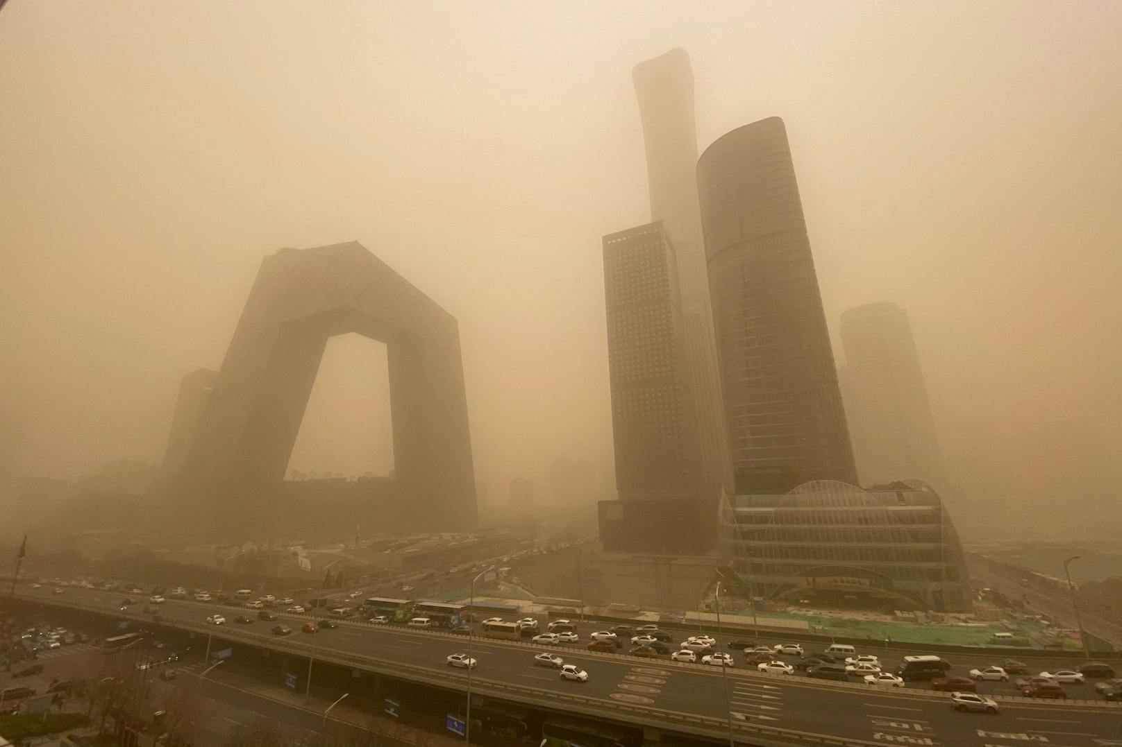 Ein heftiger Sandsturm fegt über China hinweg. In der Hauptstadt Peking verschwinden ganze Hochhäuser in dem orange-gelben Dunst (15. März 2021)