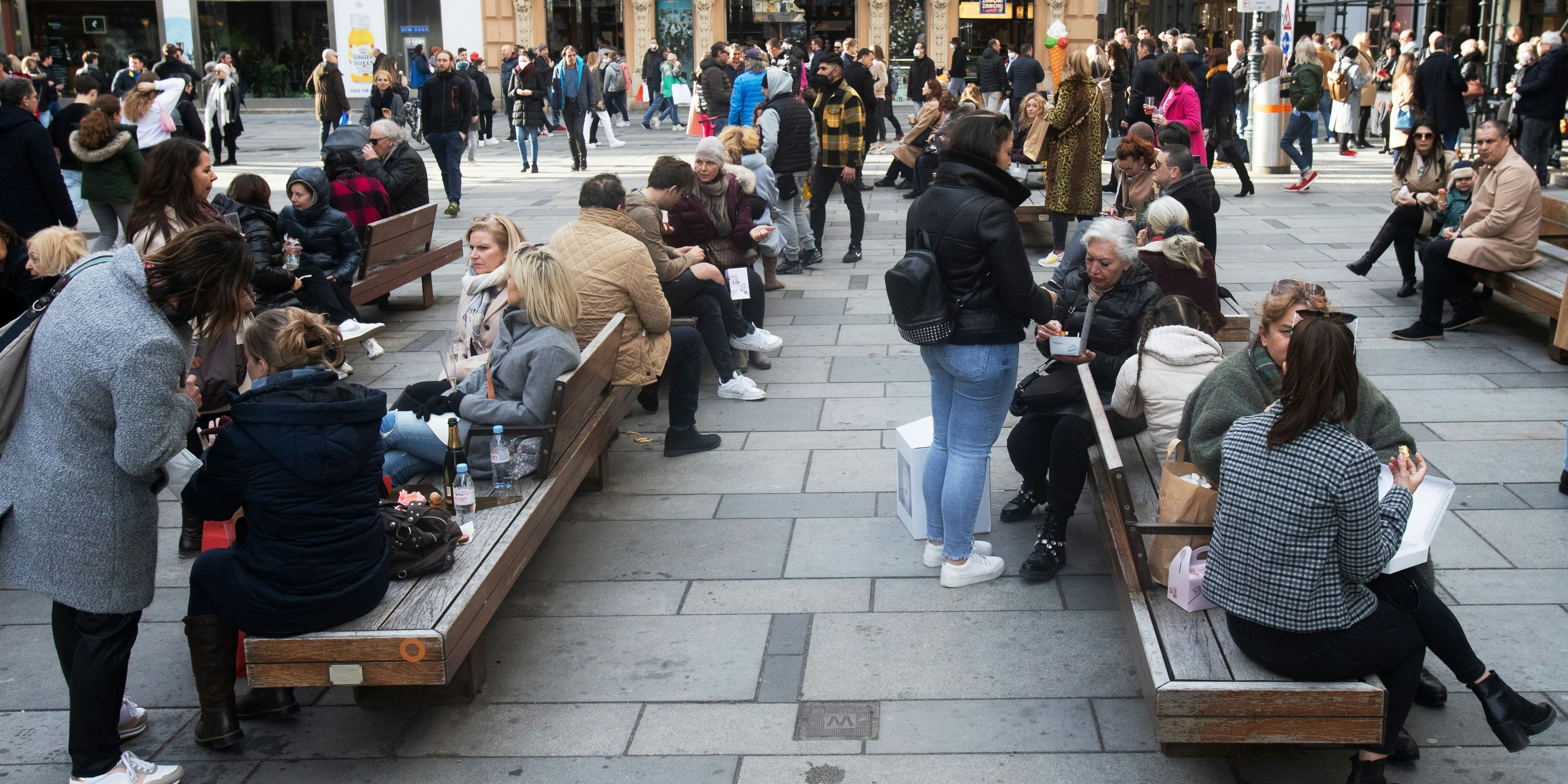 Menschen stehen bei sonnigem Wetter mit Getränken an der Kreuzung der Strasse Am Graben und der luxus Einkaufstrasse "Kohlmarkt" mit dem Michaeler Tor der Wiener Hofburg im Hintergrund in der wiener Innenstadt am Samstag, 13. März 2021. Trotz der Corona Virus (COVID - 19) tragen die wenigsten FFP 2 Schutzmasken. In Österreich ist das tragen der Schutzmasken im Geschäften verpflichtend, im freien soll ein 2 Meter Abstand eigehalten werden.