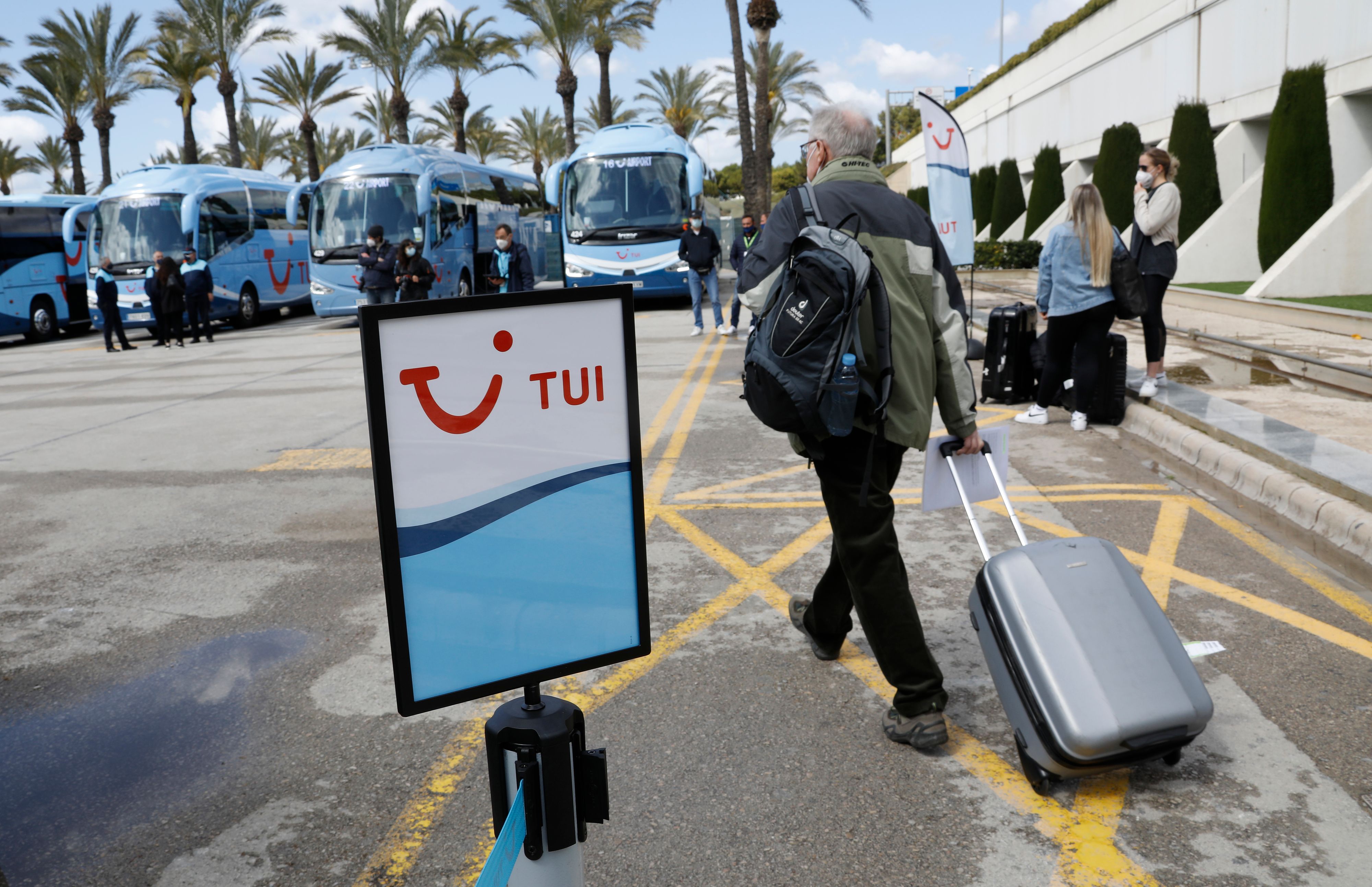 Download von www.picturedesk.com am 21.03.2021 (21:31).  21 March 2021, Spain, Palma: A passenger pulls his suitcase to the buses of the travel company Tui after arrival at Palma de Mallorca airport. The airlines are planning more flights from Germany to Mallorca for the Easter holidays due to the strong demand. Photo: Clara Margais/dpa - 20210321_PD3913 - Rechteinfo: Rights Managed (RM)