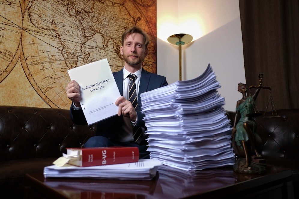 Forsthuber mit dem Berg an Akten, Dokumenten, Belegen
