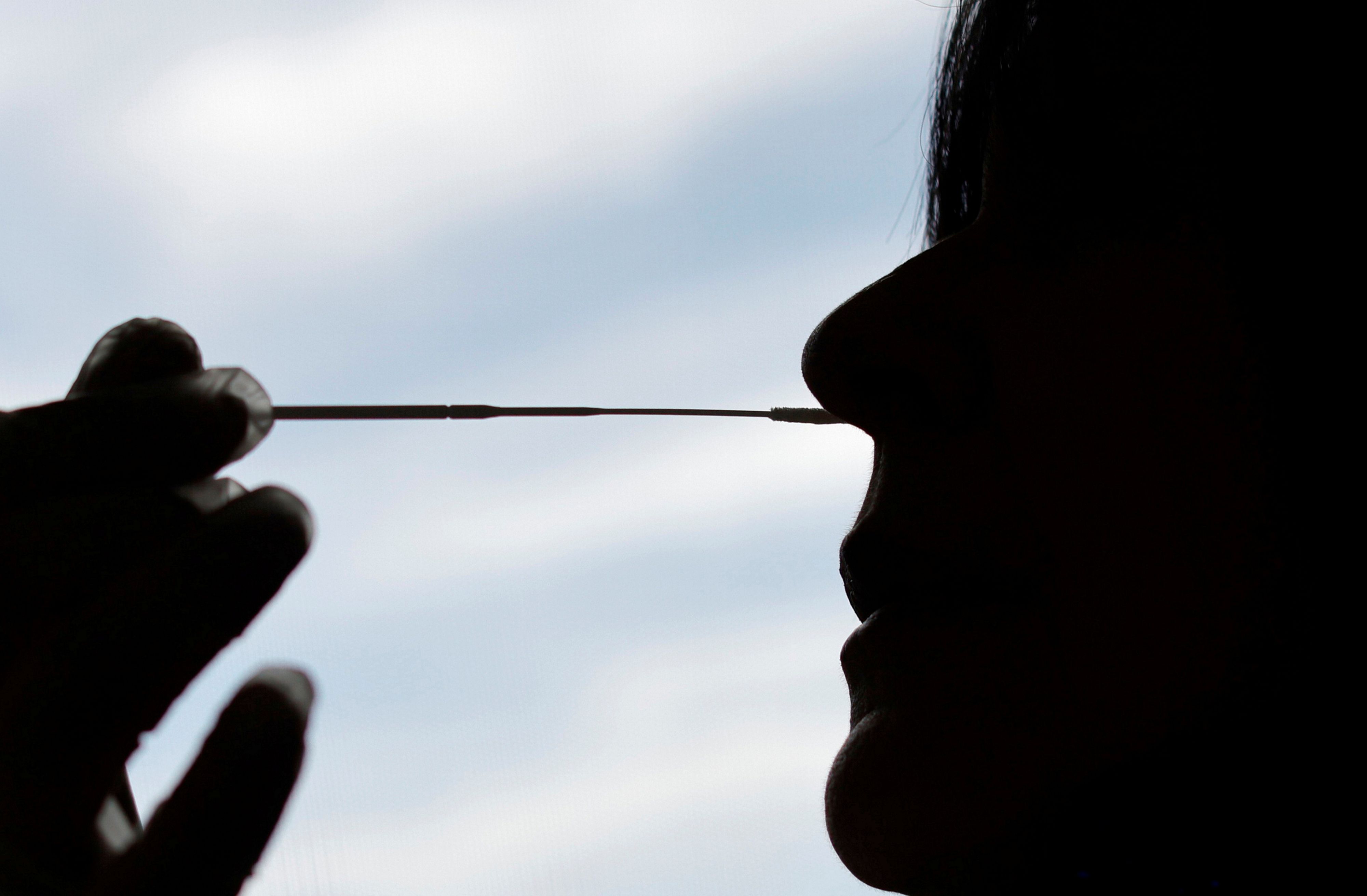 A medical worker administers a nasal swab to a patient at a COVID-19 mobile test centre called "MobilTest COVID"  at Nice railway station, as part of the coronavirus disease (COVID-19) testing campaign in Nice, France, March 12, 2021. REUTERS/Eric Gaillard
