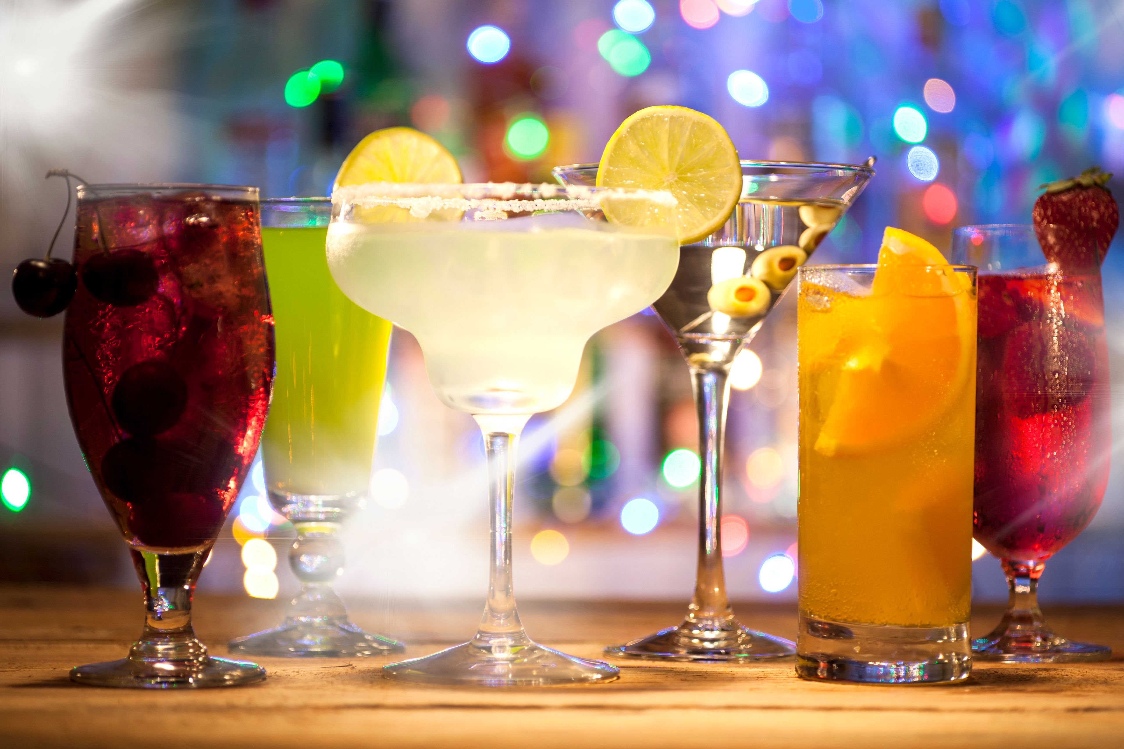 Set with different cocktails on a bar lights background.