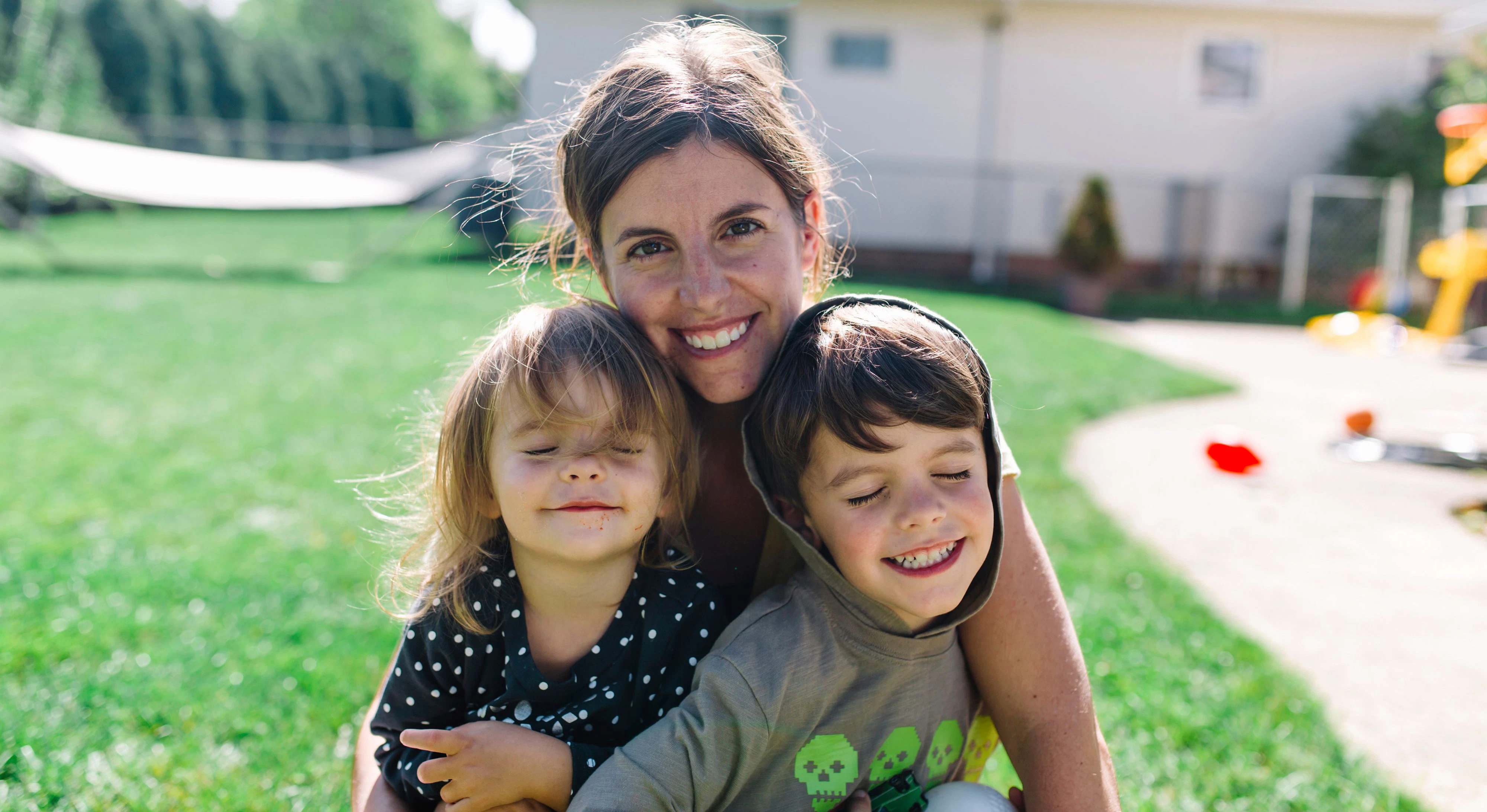 Download von www.picturedesk.com am 27.03.2021 (11:01).  Smiling woman, young girl and boy sitting on a lawn in a garden, smiling at camera. A family portrait. - 20170816_PD0787 - Rechteinfo: Royalty Free (RF) Model Released