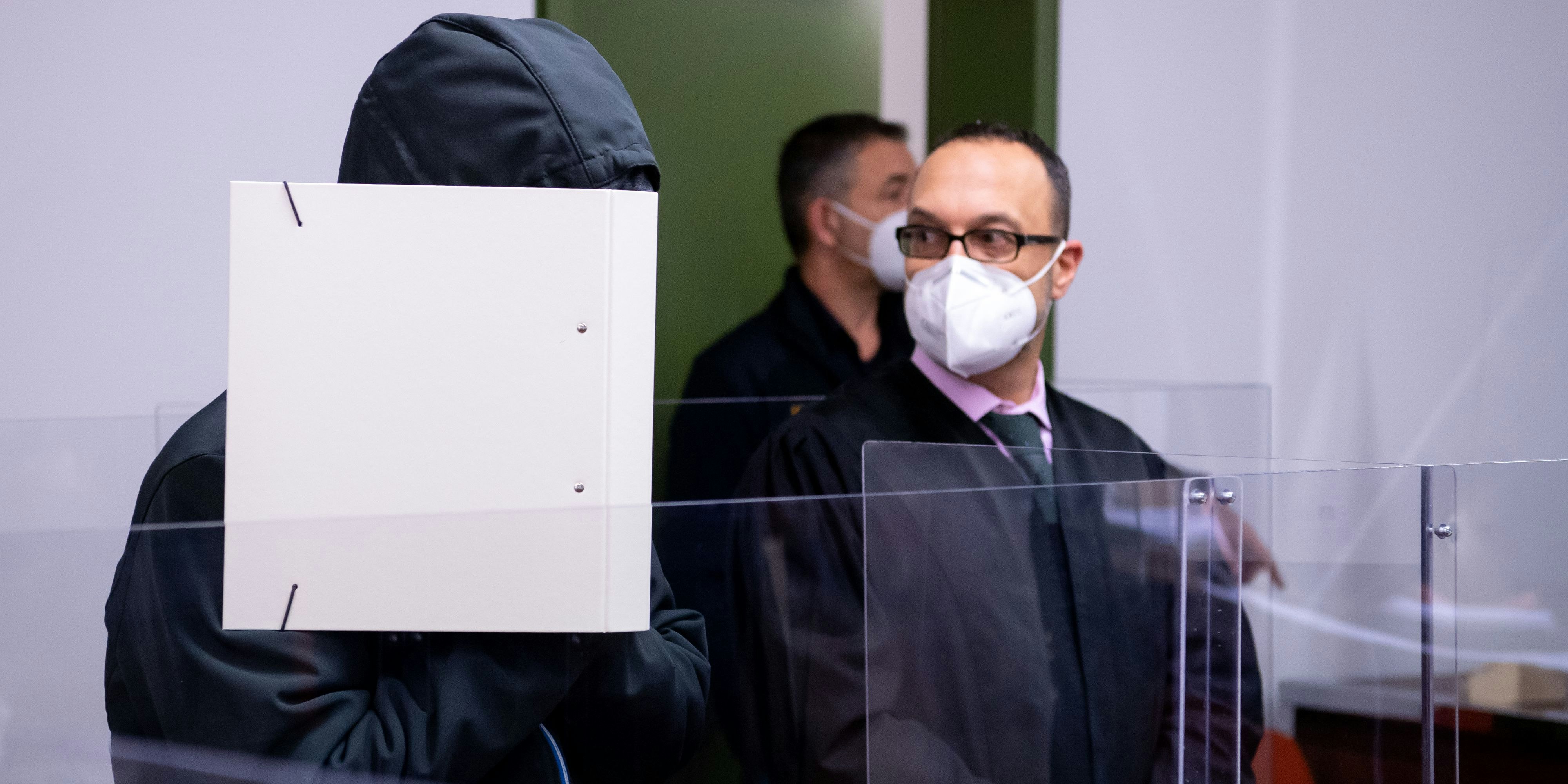 Der wegen schweren sexuellen Missbrauchs angeklagte Mann (l.) steht vor Prozessbeginn im Landgericht neben seinem Anwalt Adam Ahmed im Verhandlungssaal.