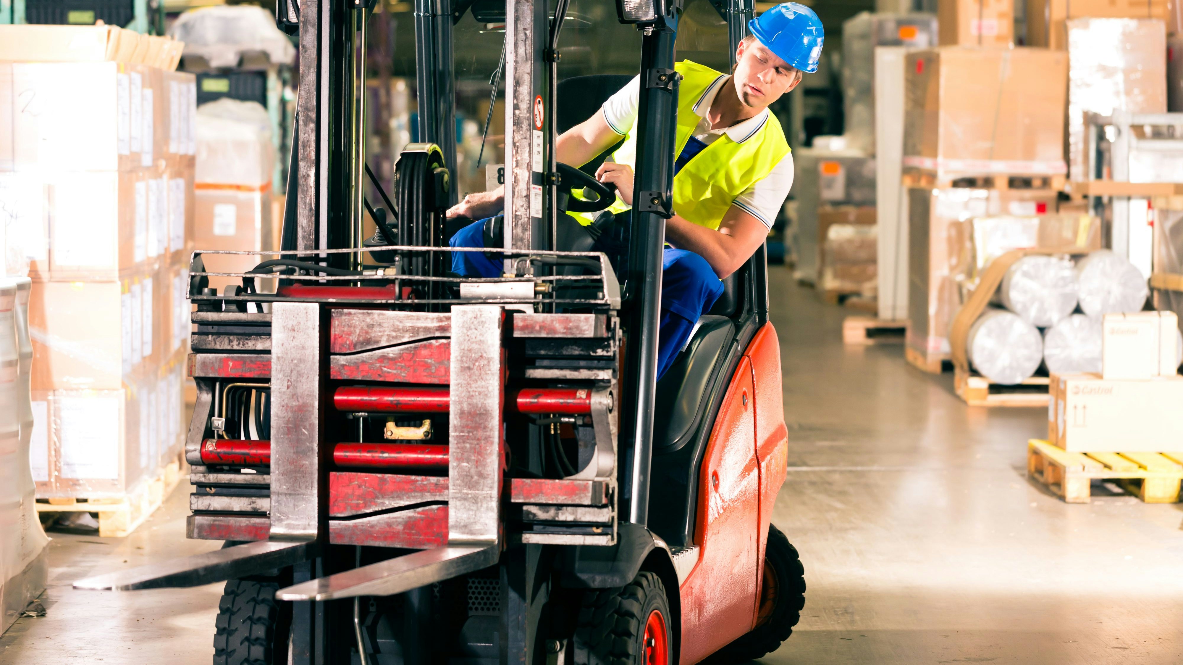 Ein Arbeiter steuert einen Gabelstapler in einem Warenlager. Symbolbild