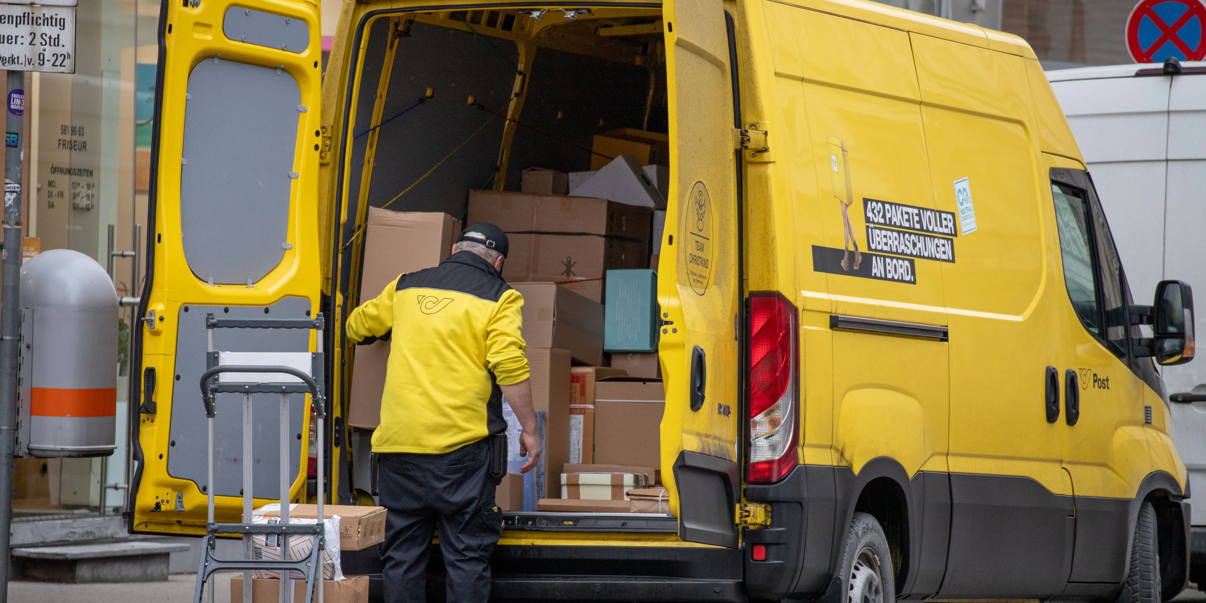 Paketzusteller der österreichischen Post mit einem gelben Lieferwagen