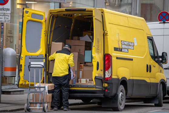 Paketzusteller der österreichischen Post mit einem gelben Lieferwagen