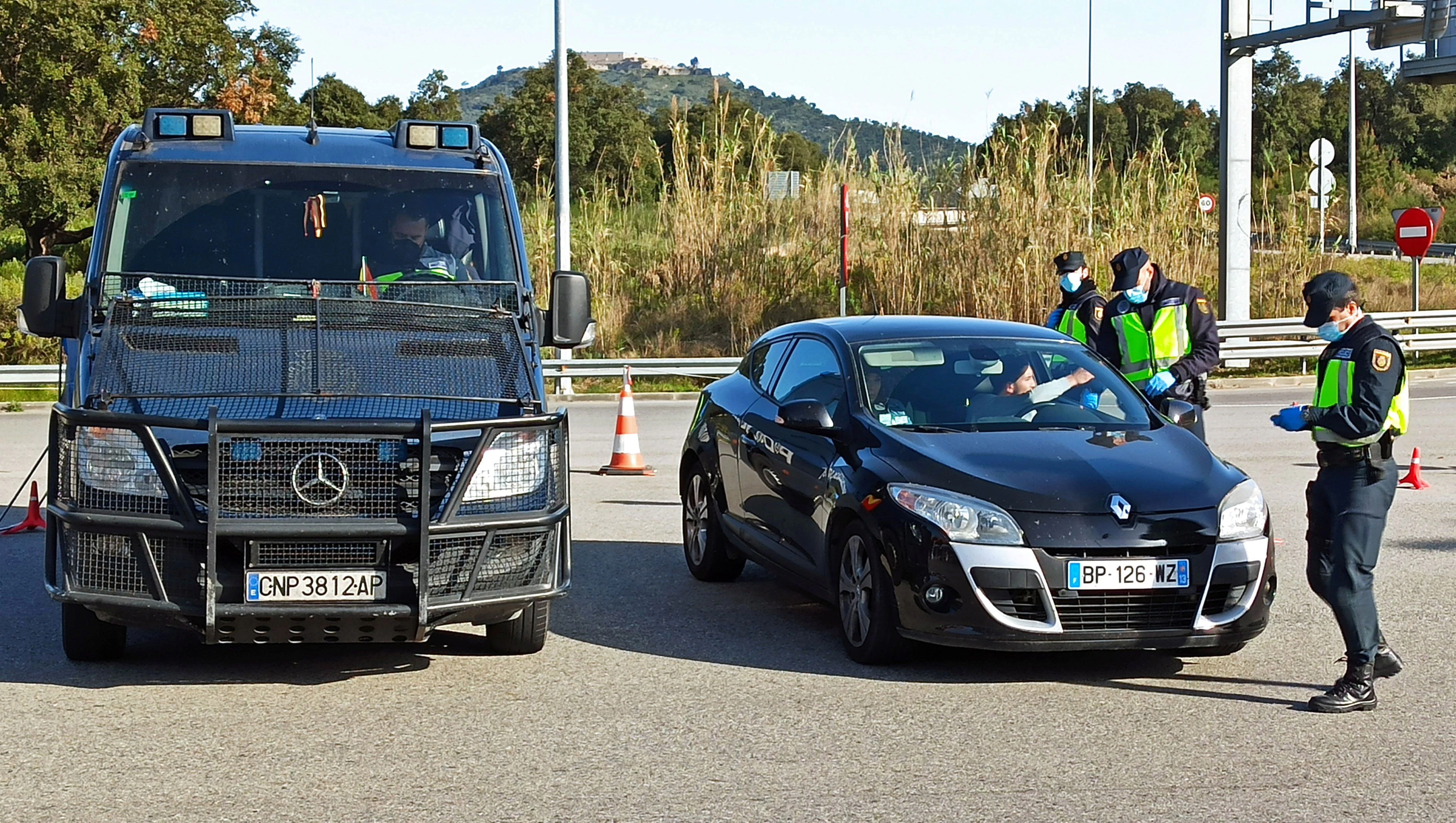 National Police officers check incoming drivers from France for negative COVID-19 tests as a measure against the coronavirus disease (COVID-19) outbreak, at a border traffic control check point in La Jonquera, Spain March 30, 2021. REUTERS/Luis Felipe Castilleja