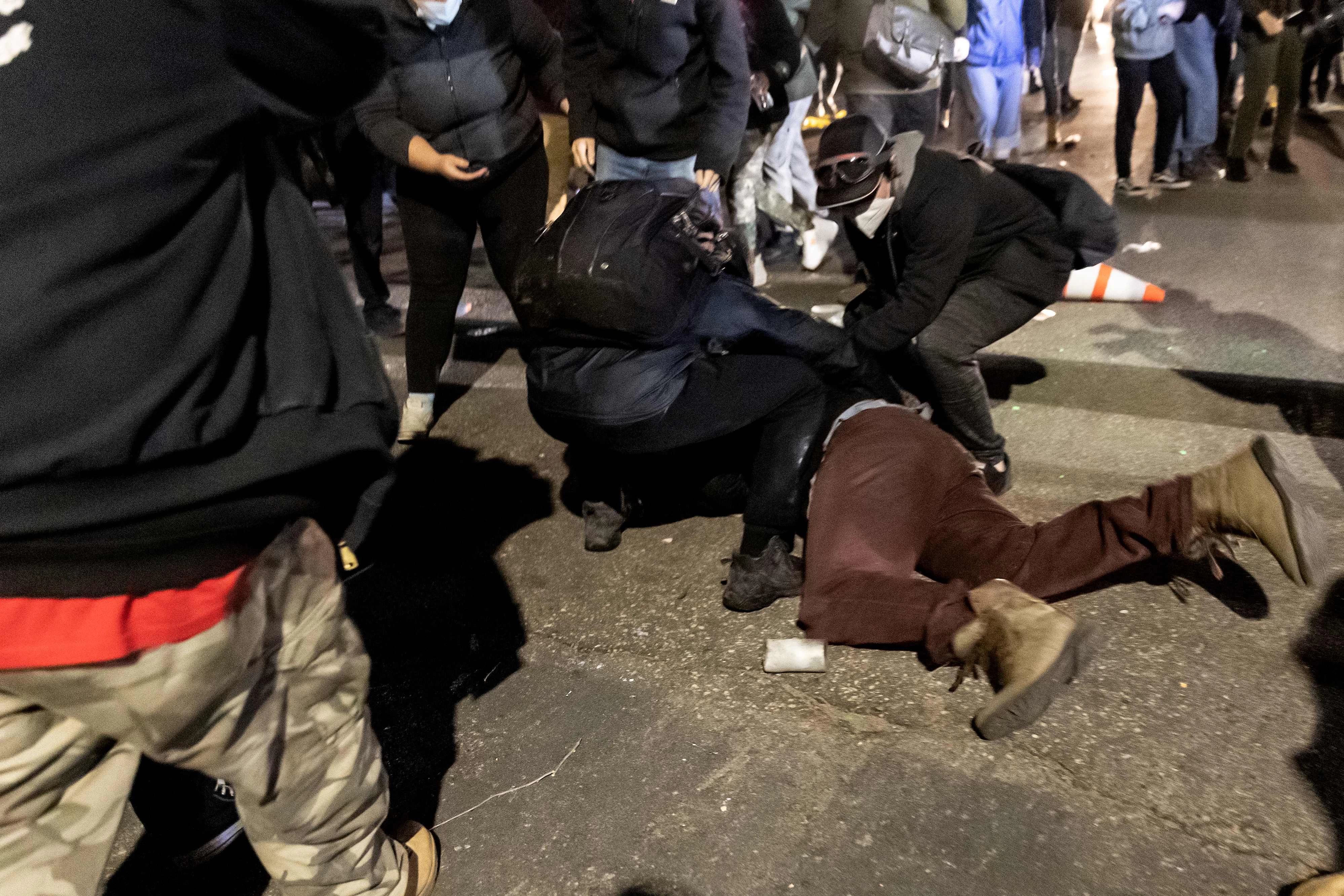 Download von www.picturedesk.com am 12.04.2021 (08:47).  A demonstrator is helped by others after being injured by a tear-gas bomb in front of the Brooklyn Center Police Station as people gather to protest after a police officer shot and killed a black man in Brooklyn Center, Minneapolis, Minnesota on April 11, 2021. - Protests broke out April 11, 2021 night after US police fatally shot a young Black man in a suburb of Minneapolis -- where a former police officer is currently on trial for the murder of George Floyd. Hundreds of people gathered outside the police station in Brooklyn Center, northwest of Minneapolis. Police fired teargas and flash bangs at the demonstrators, according to an AFP videojournalist at the scene. (Photo by Kerem Yucel / AFP) - 20210411_PD13172 - Rechteinfo: Rights Managed (RM) Nur für redaktionelle Nutzung! Werbliche Nutzung erfordert Freigabe: bitte schicken Sie uns eine Anfrage.