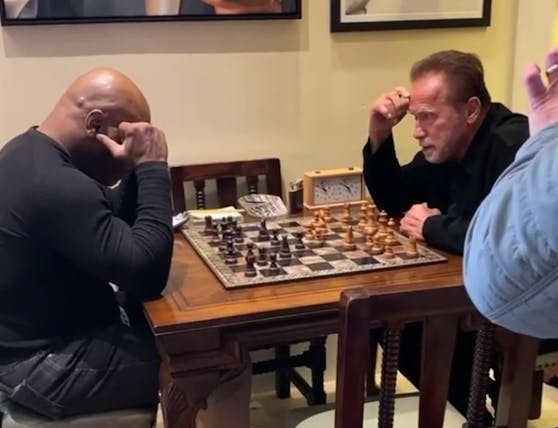 Mike Tyson und Arnold Schwarzenegger beim mentalen Armdrücken.