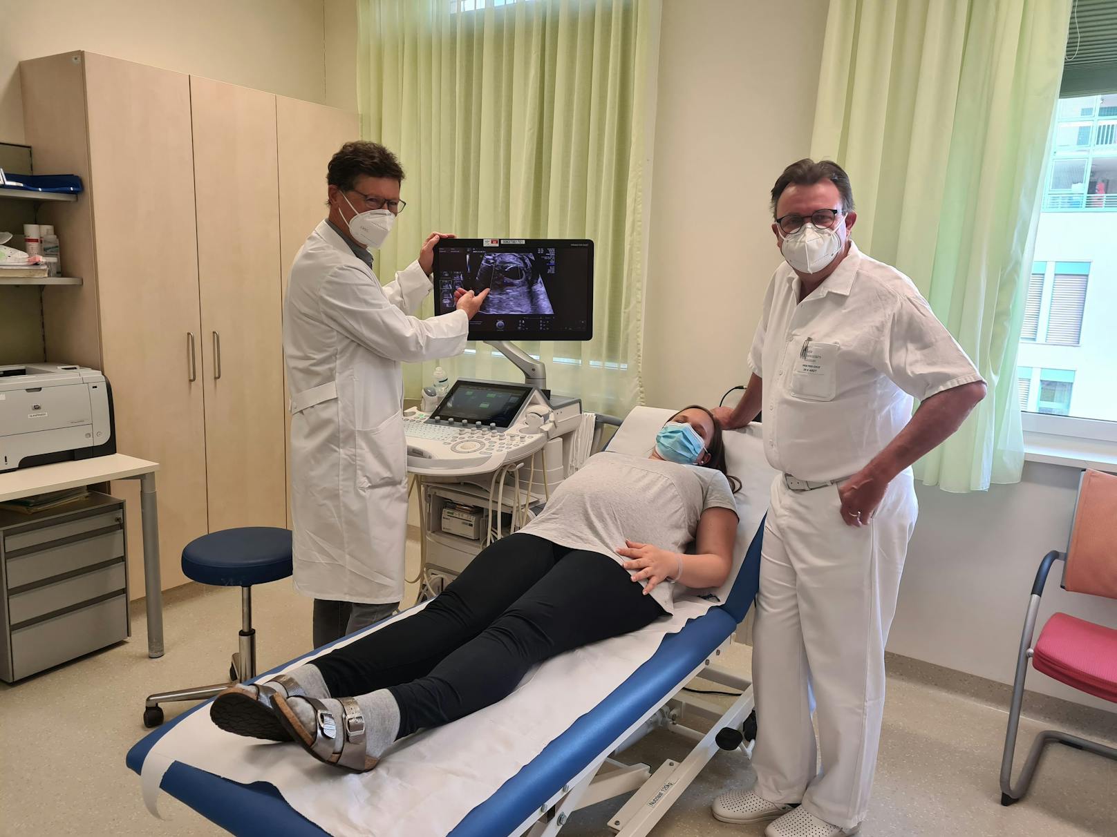 Die beiden Ärzte zeigen die Zwillinge auf dem Ultraschallbild.