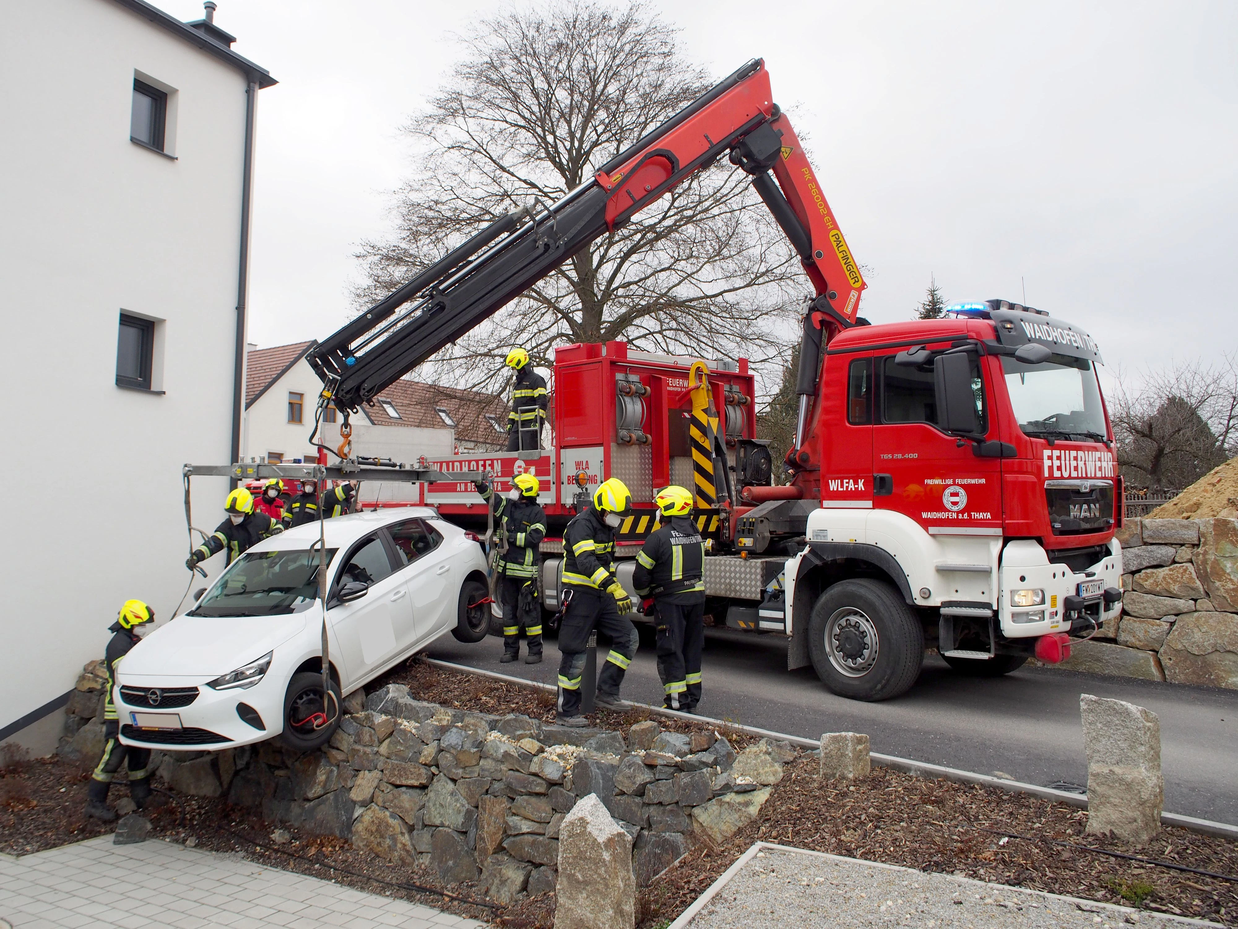 Die Feuerwehr hob den Wagen vorsichtig von der Mauer.