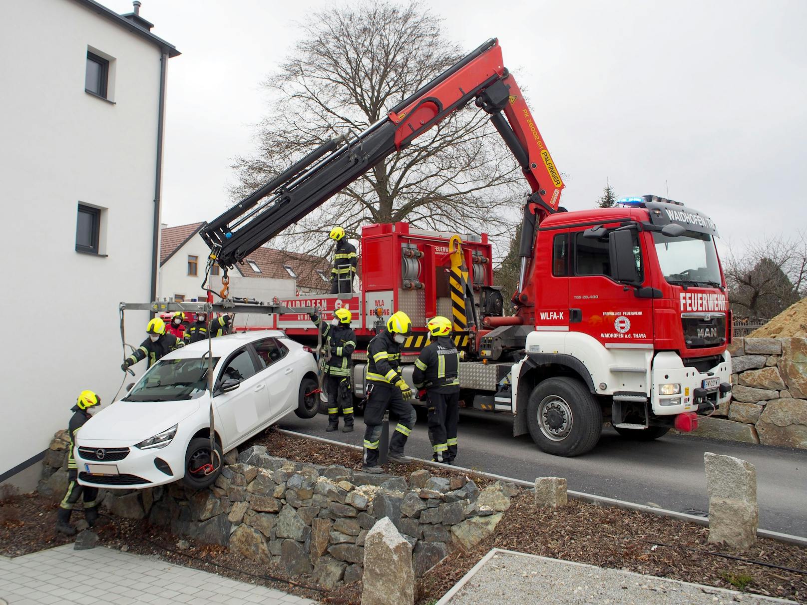 Die Feuerwehr hob den Wagen vorsichtig von der Mauer.