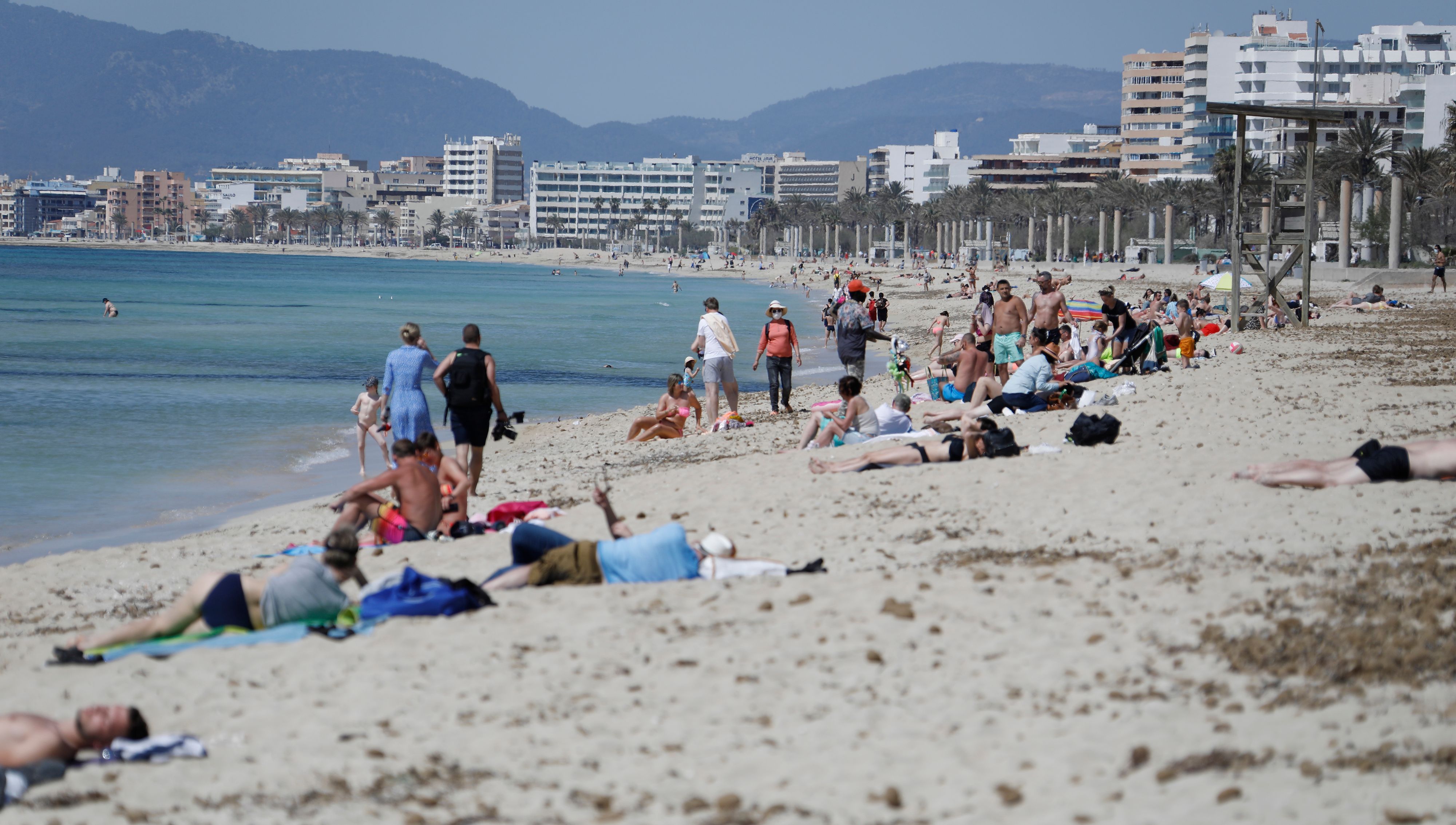 Download von www.picturedesk.com am 02.04.2021 (14:48).  31 March 2021, Spain, Palma de Mallorca: People sunbathe on the beach of El Arenal. When sunbathing on the beach, people are still allowed to take off the Corona protective mask on the Spanish holiday island and also in other coastal regions of the country. "If you meet on the beach with people from outside the household, you must wear mask," explained Minister Gómez. However, those who enjoy the sun and sea alone or with people of their own household are allowed to do so "topless". (to dpa Sunbathing on the Ballermann beach but still allowed without a mask) Photo: Clara Margais/dpa - 20210331_PD4050 - Rechteinfo: Rights Managed (RM)