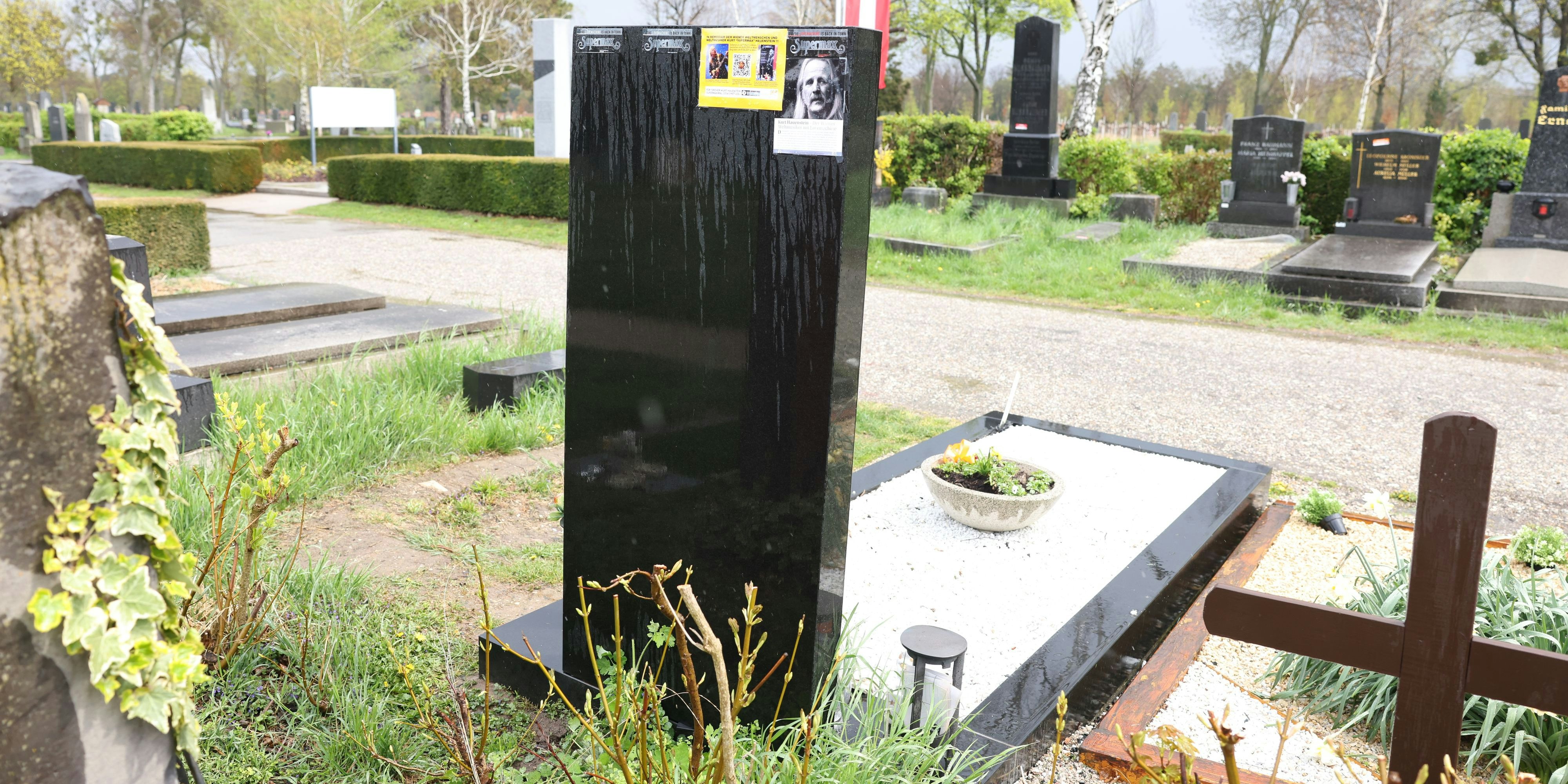 Auf dem Grabstein von "Supermax"-Star Kurt Hauenstein klebt Werbung für ihn.