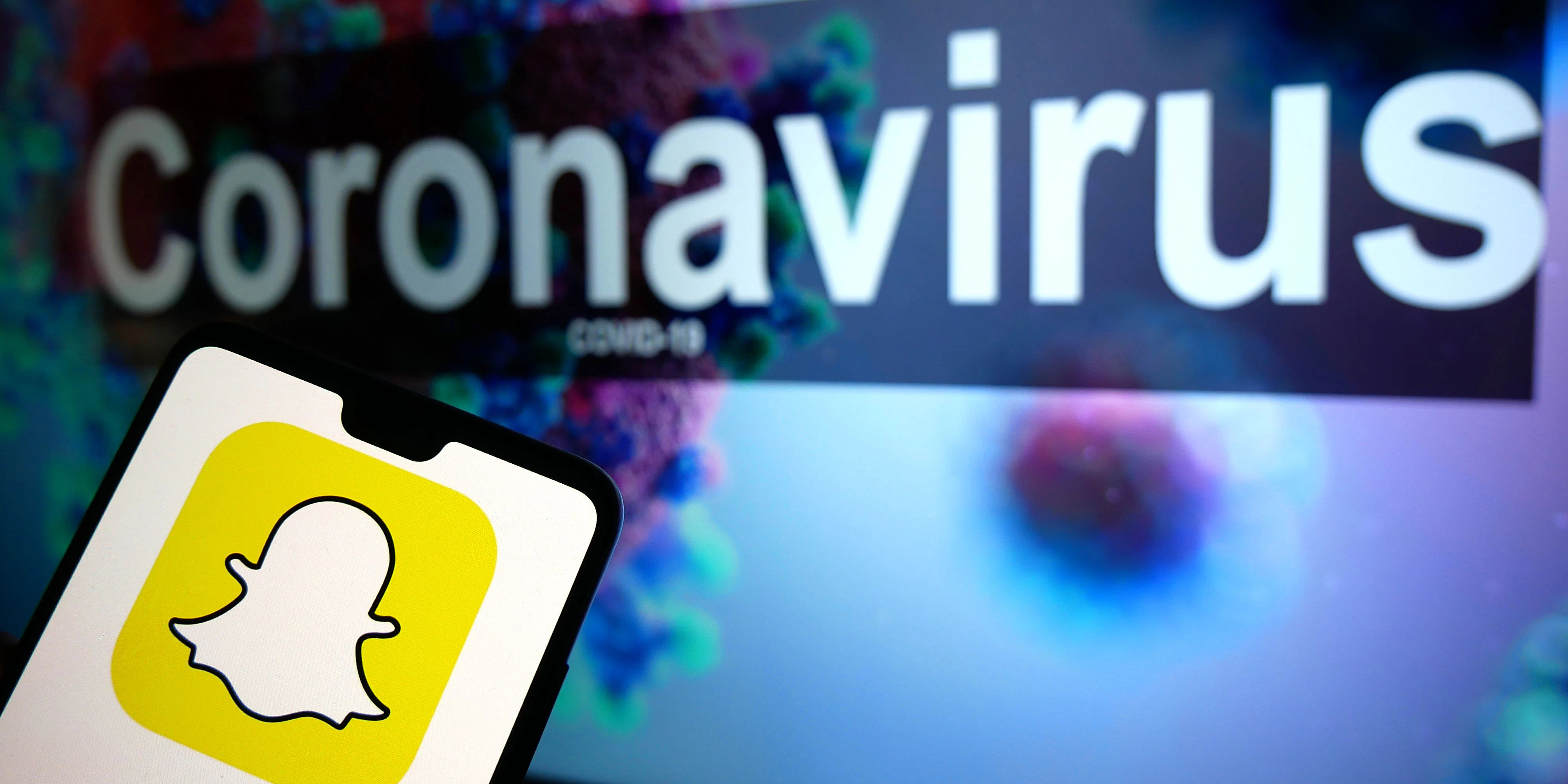 Download von www.picturedesk.com am 24.04.2021 (14:19).  The Snapchat logo seen displayed on a mobile phone with an illustrative model of the Coronavirus displayed on a monitor in the background. Photo credit should read: James Warwick/EMPICS Entertainment - 20200329_PD2569 - Rechteinfo: Rights Managed (RM)