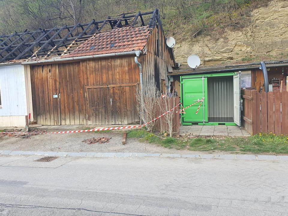 Neben dem abgebrannten Familienhaus steht jetzt ein Spendencontainer.