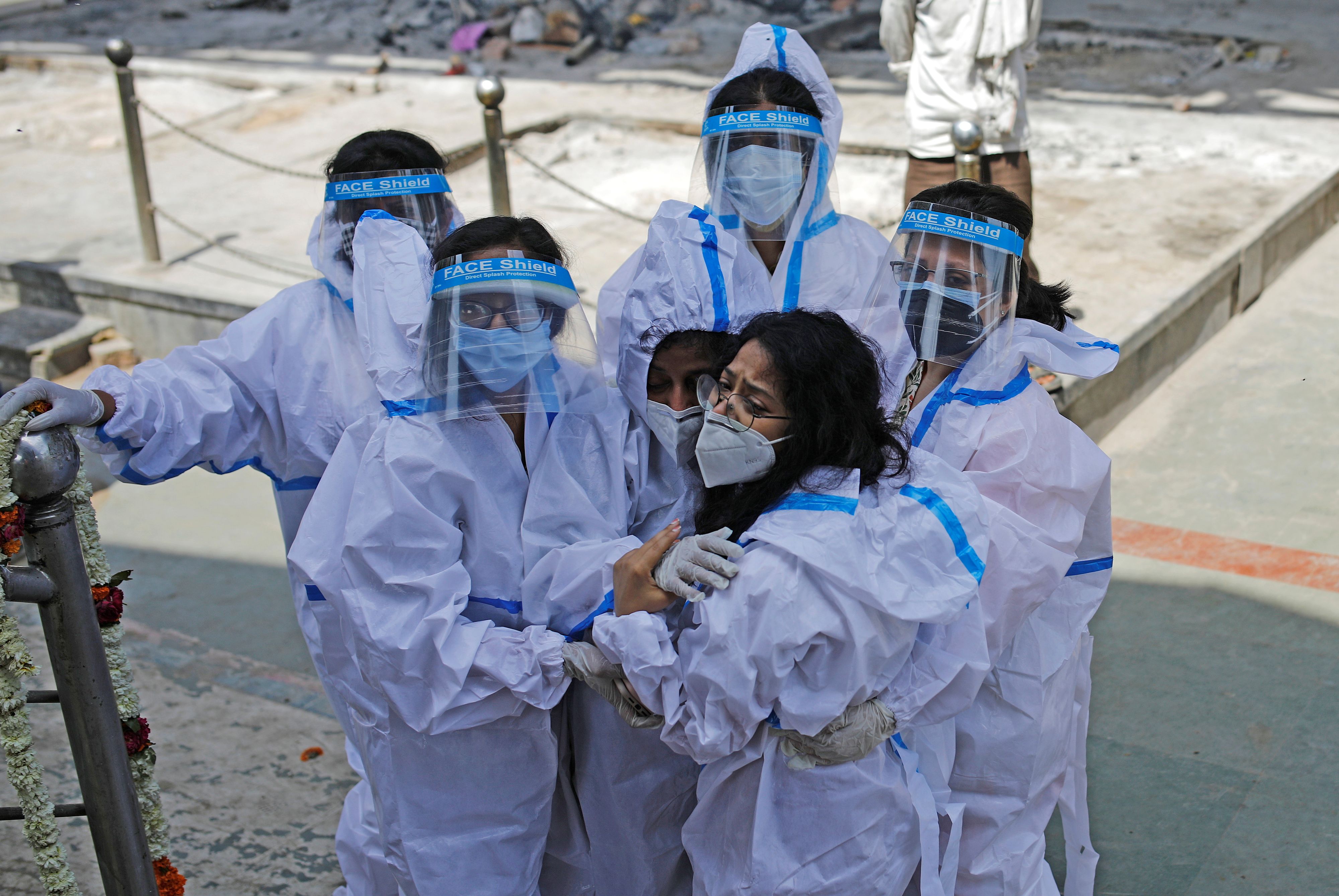 Relatives wearing personal protective equipment (PPE) mourn a man, who died from the coronavirus disease (COVID-19), at a crematorium in New Delhi, India April 21, 2021. REUTERS/Adnan Abidi