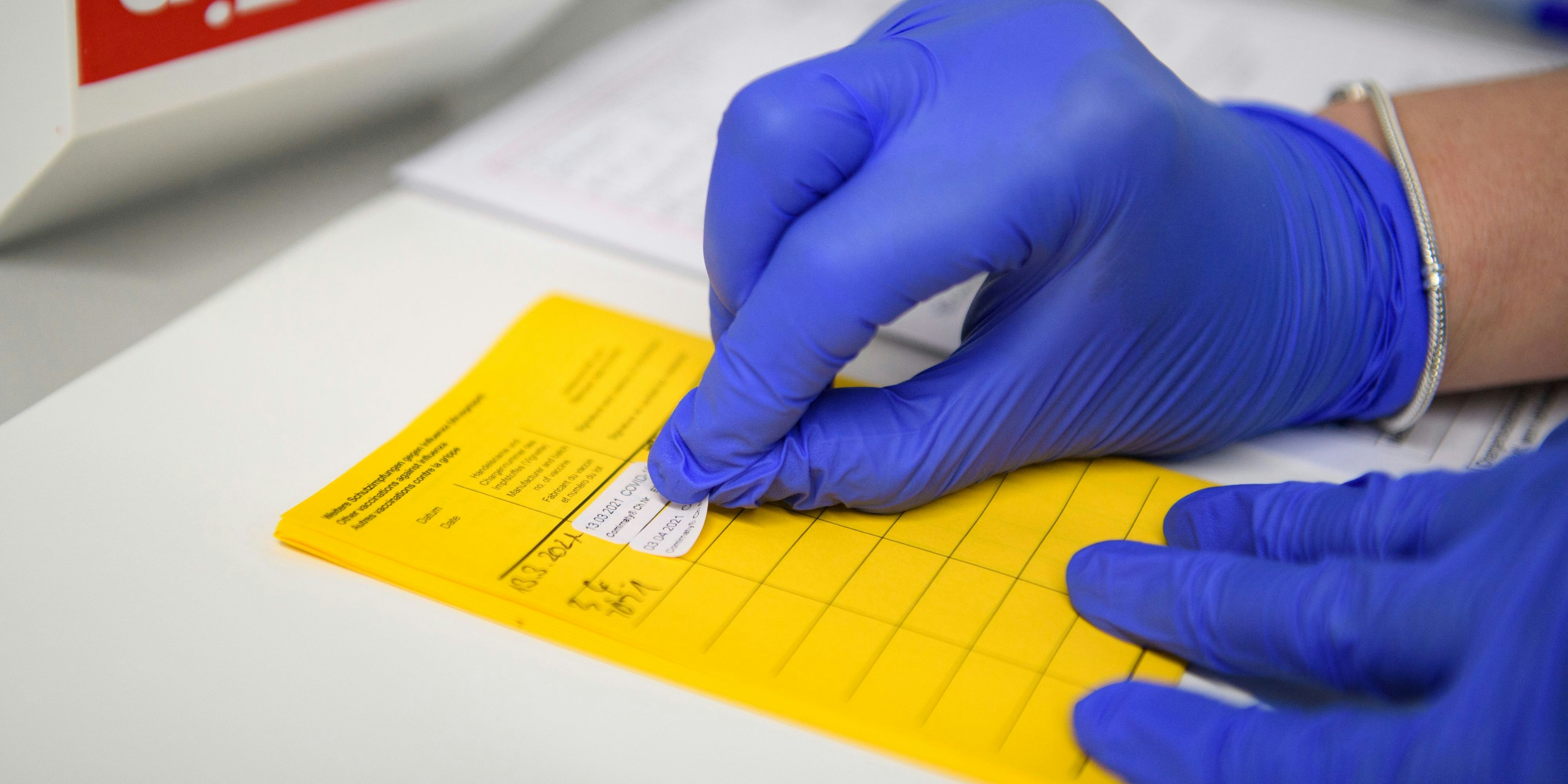 Download von www.picturedesk.com am 26.04.2021 (17:25).  03 April 2021, North Rhine-Westphalia, Velen: Information about the vaccination is entered in the vaccination certificate. People aged 60 and over can make an appointment for vaccination with the active substance from Astrazeneca in North Rhine-Westphalia from today. The first over-60s were even vaccinated today. Photo: Christopher Neundorf/dpa - 20210403_PD3230 - Rechteinfo: Rights Managed (RM)