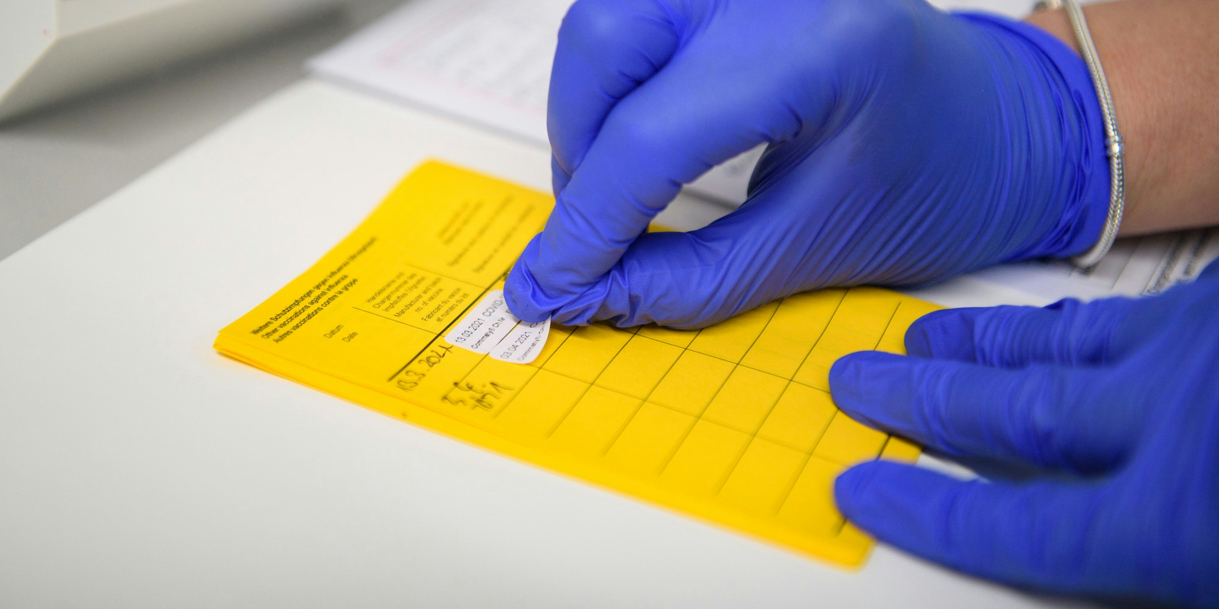 Download von www.picturedesk.com am 26.04.2021 (17:25).  03 April 2021, North Rhine-Westphalia, Velen: Information about the vaccination is entered in the vaccination certificate. People aged 60 and over can make an appointment for vaccination with the active substance from Astrazeneca in North Rhine-Westphalia from today. The first over-60s were even vaccinated today. Photo: Christopher Neundorf/dpa - 20210403_PD3230 - Rechteinfo: Rights Managed (RM)