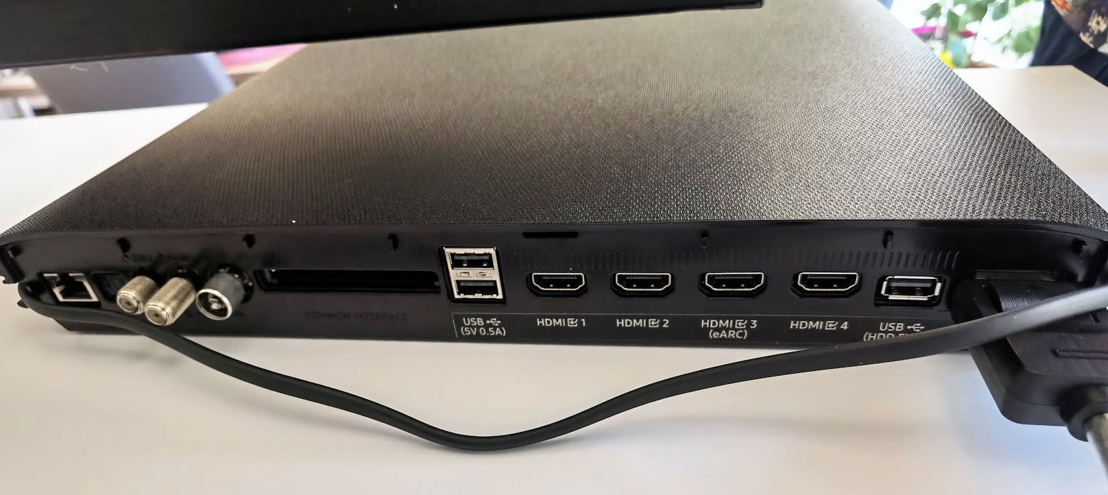 Die Box ist gleichzeitig auch das Anschluss-Herzstück des Fernsehers, das ihn per Kabel mit Strom versorgt und alle möglichen Anschlüsse von Antennen-Verbindungen sowie vier HDMI-2.1-Eingängen über drei USB-Ports bis hin zum CI-Steckplatz bietet.