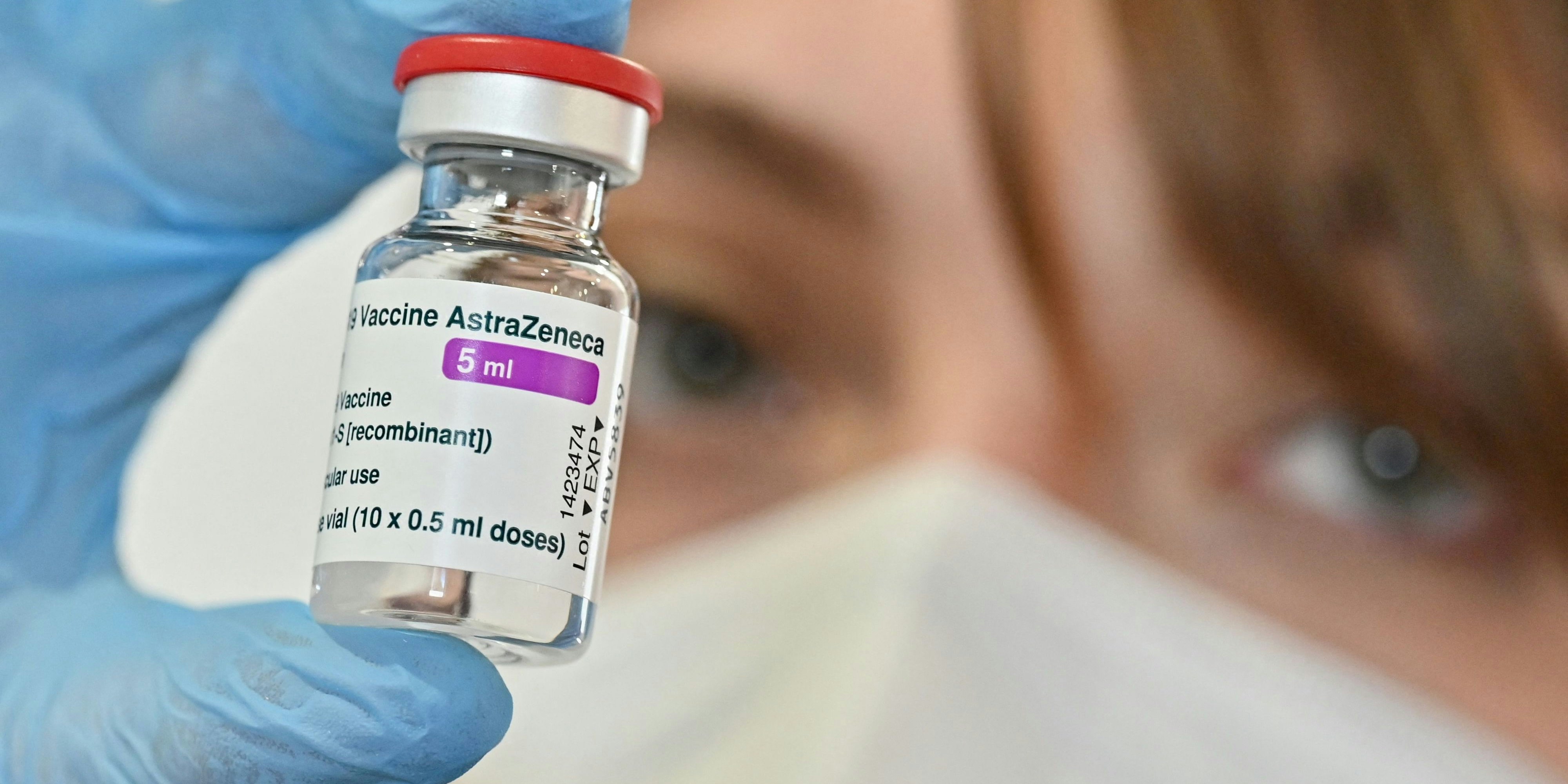 Eine Frau hält eine Ampulle des AstraZeneca-Impfstoffs. Symbolbild