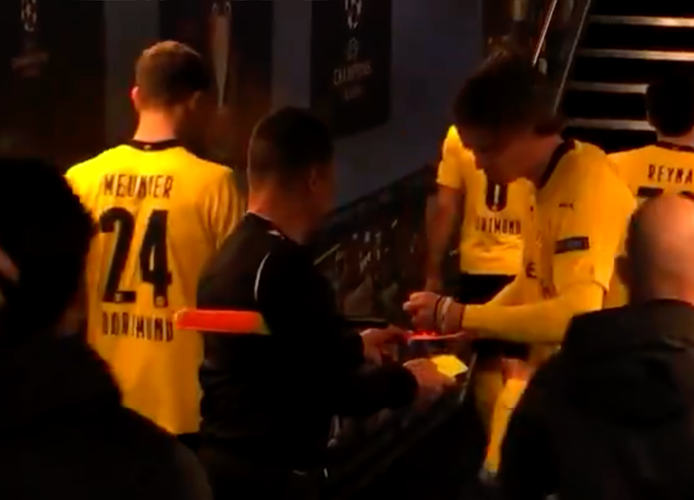 Erling Haaland gibt dem Linienrichter ein Autogramm.